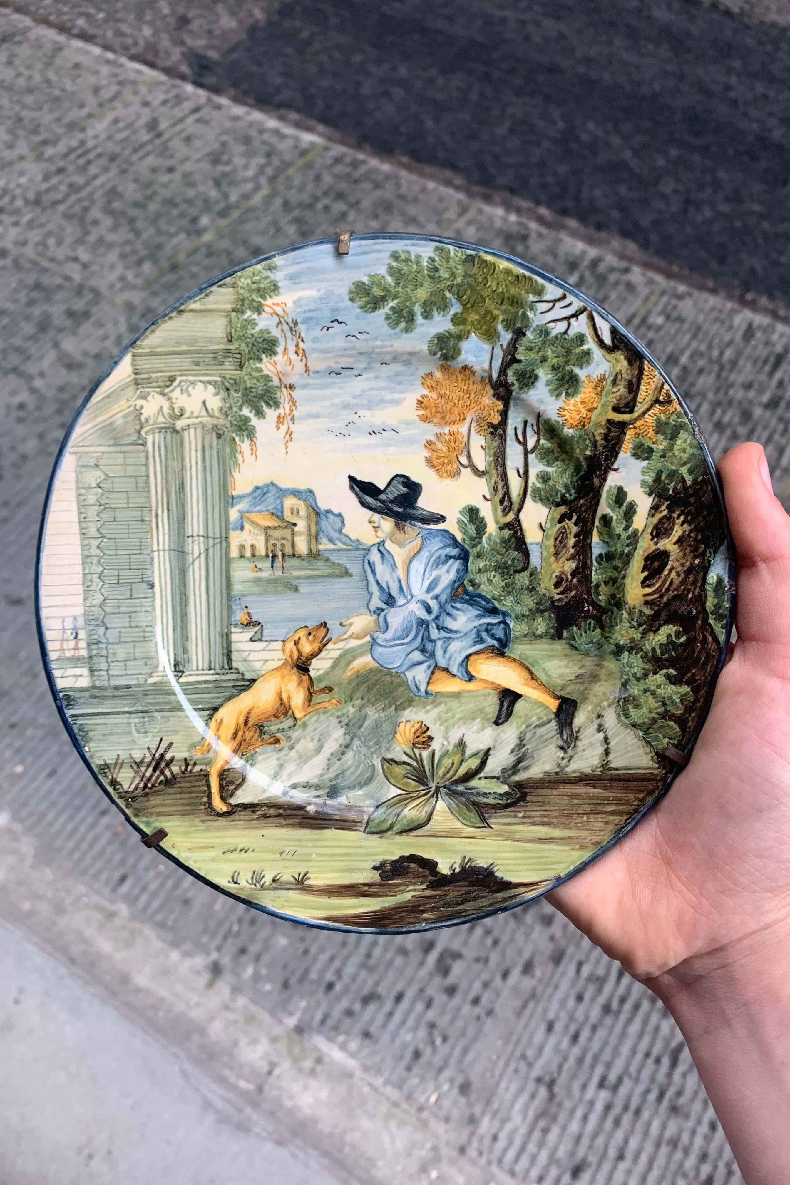 Castelli maiolica dish with young man in black hat, dog and classical ruins, mid-18th century
Polychrome tin-glazed maiolica (grand feu)
Italy, Castelli d’Abruzzo, mid-18th century
Diameter: approx. 17.5 cm

Hand-painted maiolica dish from Castelli,