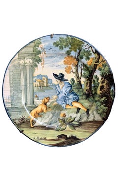 Maiolica-Teller von Castelli. Junger Mann mit schwarzem Hut, Hund und klassischen Ruinen.