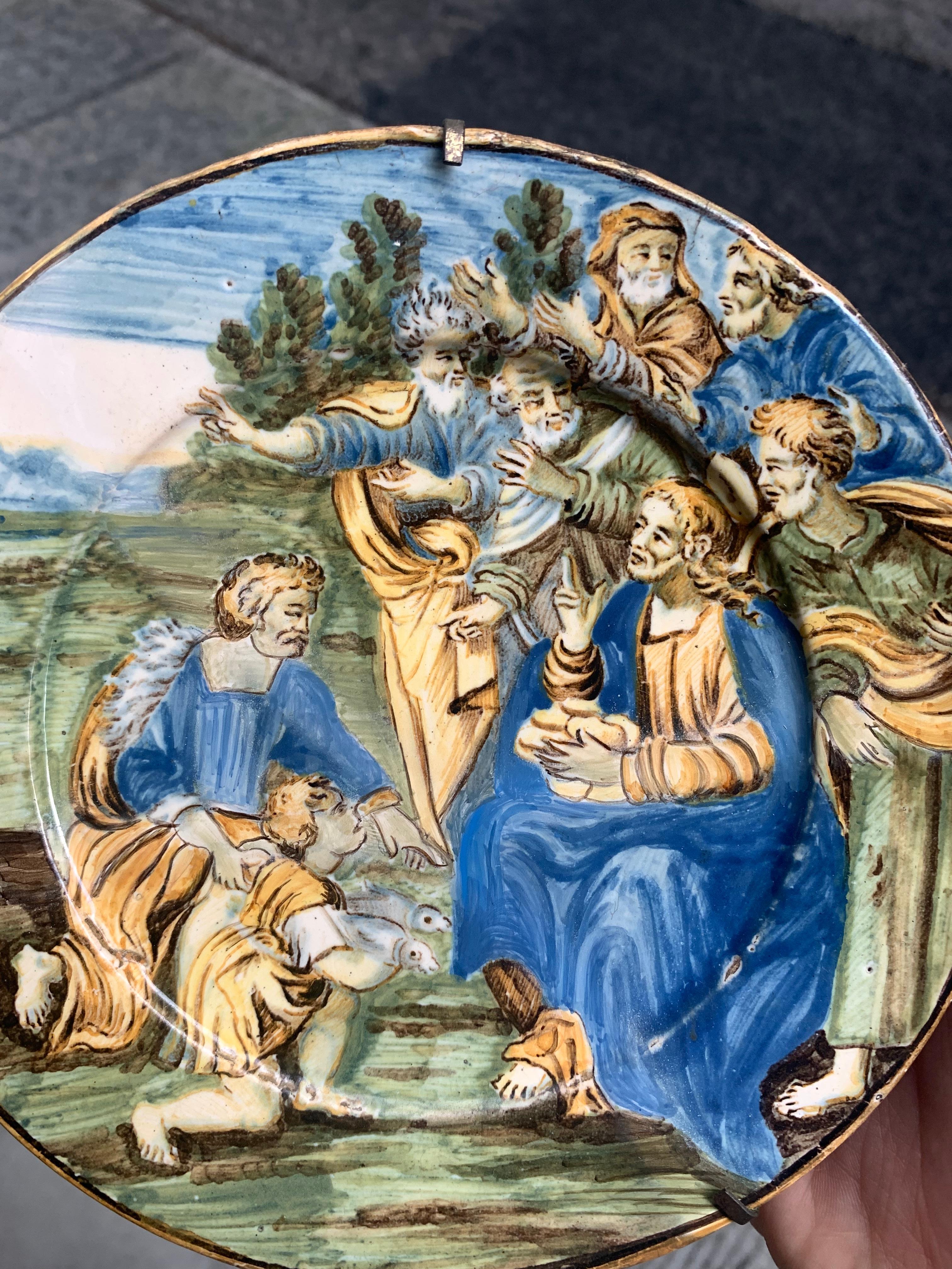 Castles of Abruzzo.  
Italian Maiolica, dish with the Miracle of the loaves and fishes.
Mid-18th century.
Polychrome tin-glazed majolica painted by hand.
Castles, Abruzzo, mid-18th century 
Diameter: approx. 17.5 cm 

Decorative maiolica dish,