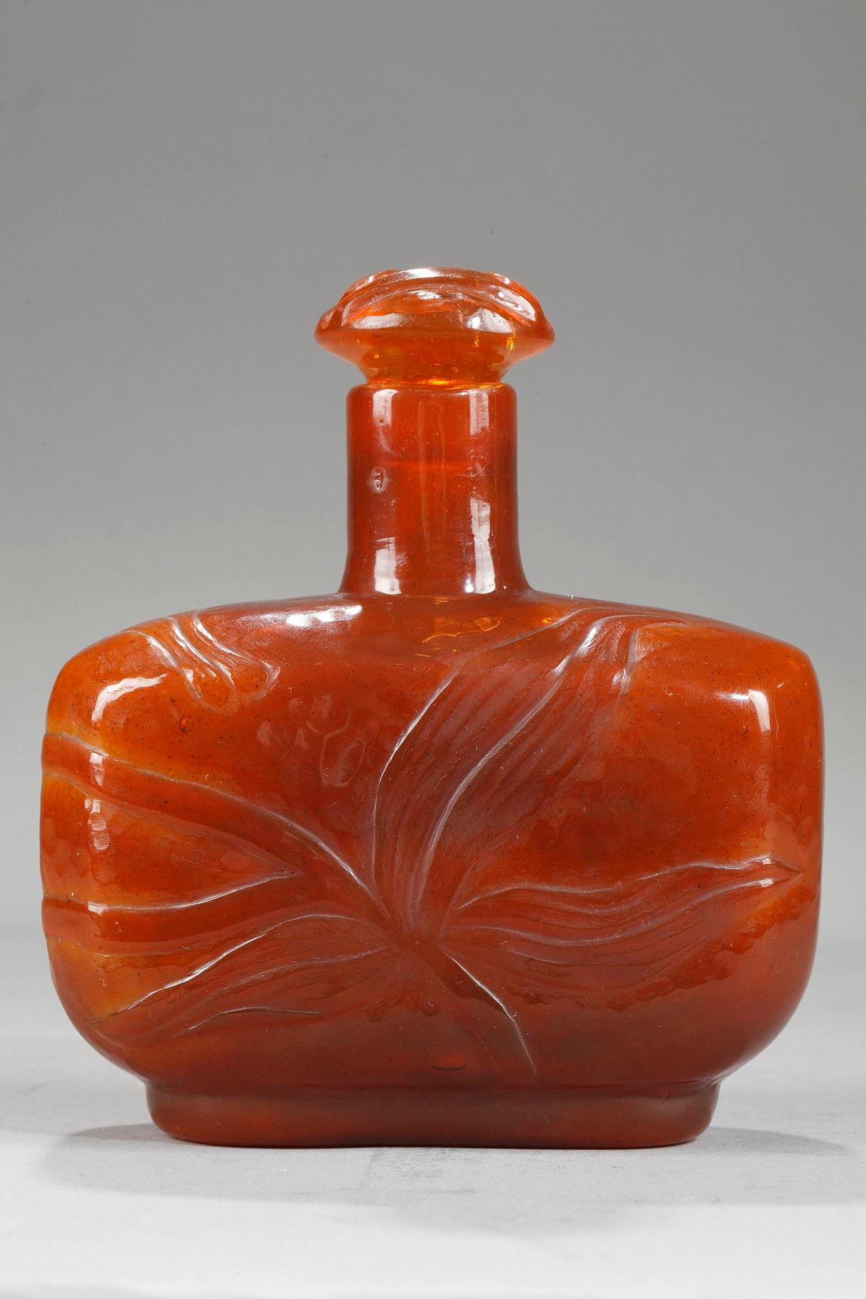 Bottle with Lily
by Emile GALLE (1846-1904)
 
Bottle in orange colored blown-glass
with its original cap,
decorated with lilies,
etched and worked with a wheel

Japanese style signature underneath 