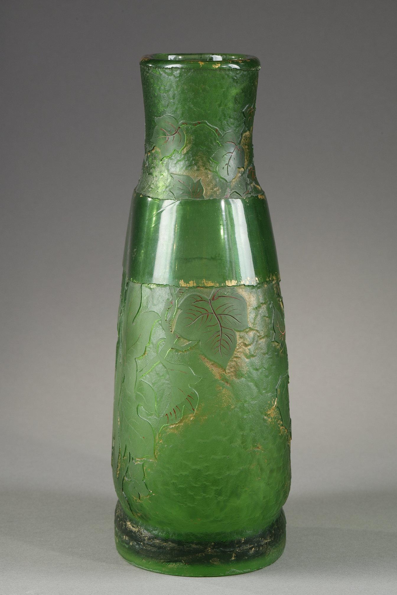 Ivy Vase
by Ernest LEVEILLE (1841–1913)

Flat body shaped vase in green blown-molded glass, 
with ivy decoration
Acid-etched decor in reserve for the leaves,
enhanced with gold for the background, 
and red enamelled painting for the nerves of the