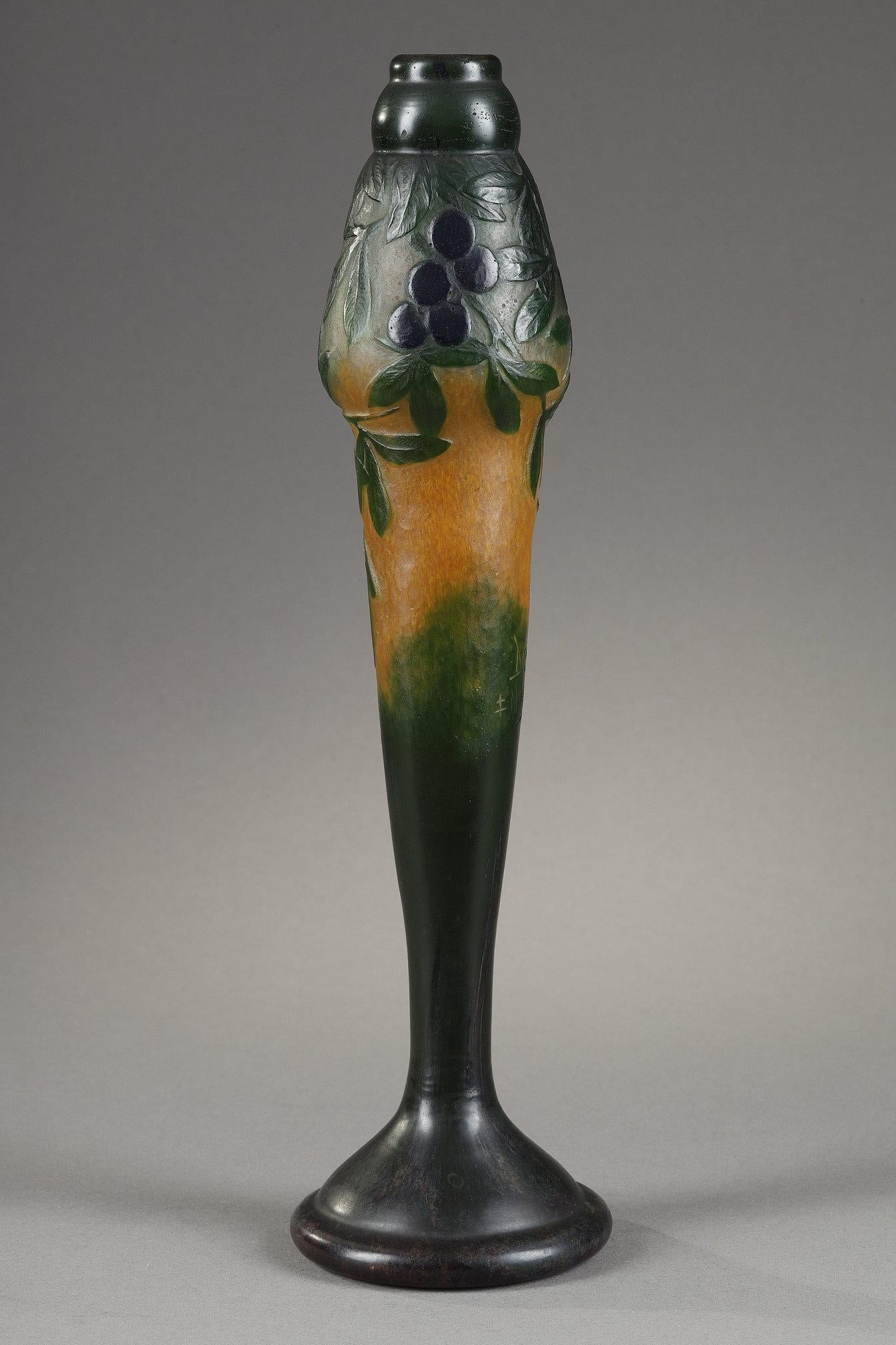 Vase with sloes
by DAUM

A spindle-shaped vase 
with a blue sloe plaques decor
Multilayer blown-molded glass, colored by vitrification of powders
With an acid-etched decor in reserve for the green leaves, then finely worked with the wheel,
on an