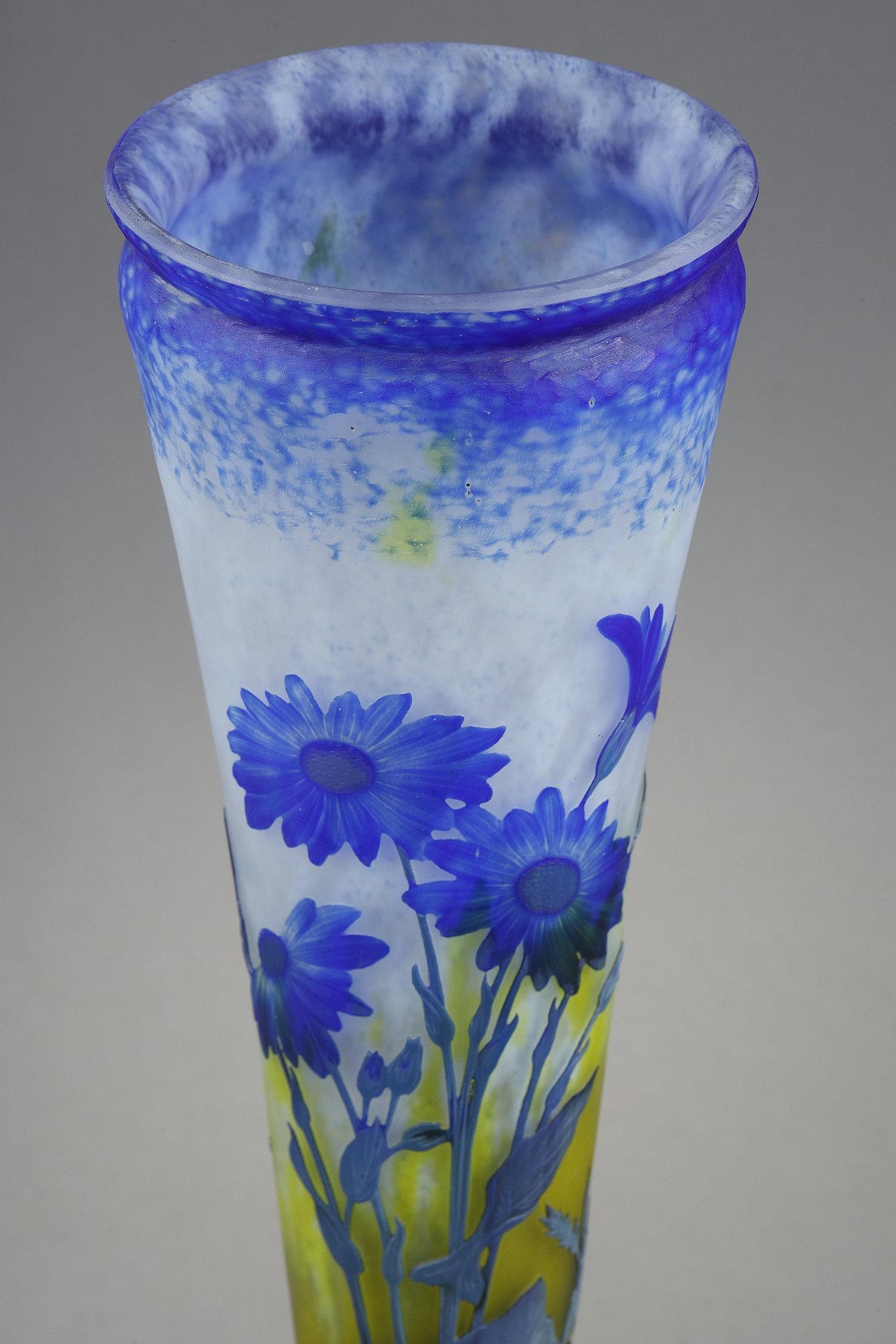 Vase with Asters
by DAUM

A cornet-shaped vase on foot,
Multi-layer blown-molded glass,
with blue Asters decoration.
With acid-etched decor in reserve, and wheel-carved flowers.
With hammered background to the top of the vase.

Signed to the foot 