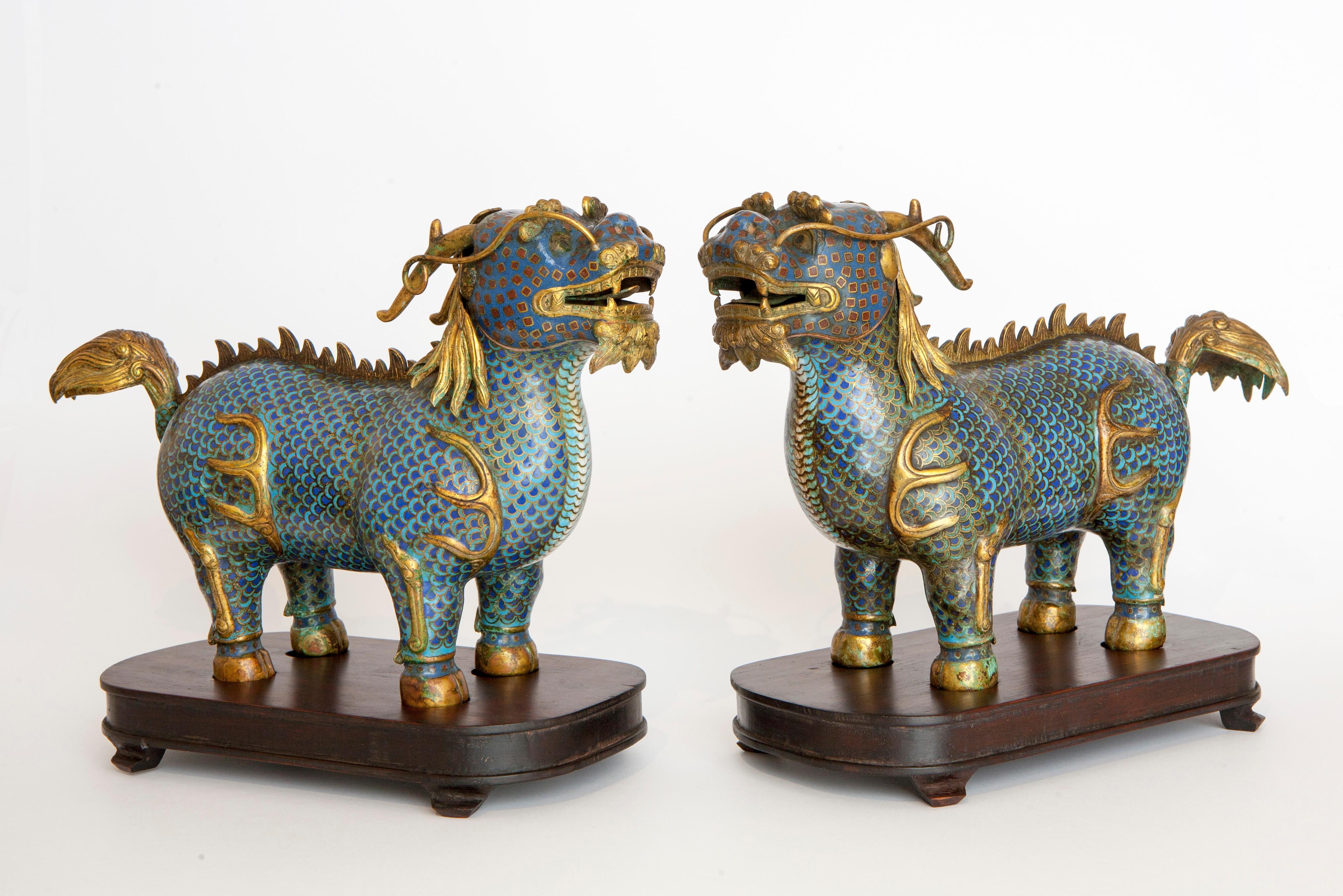 Pair of Qilin in cloisonné resting on wooden bases