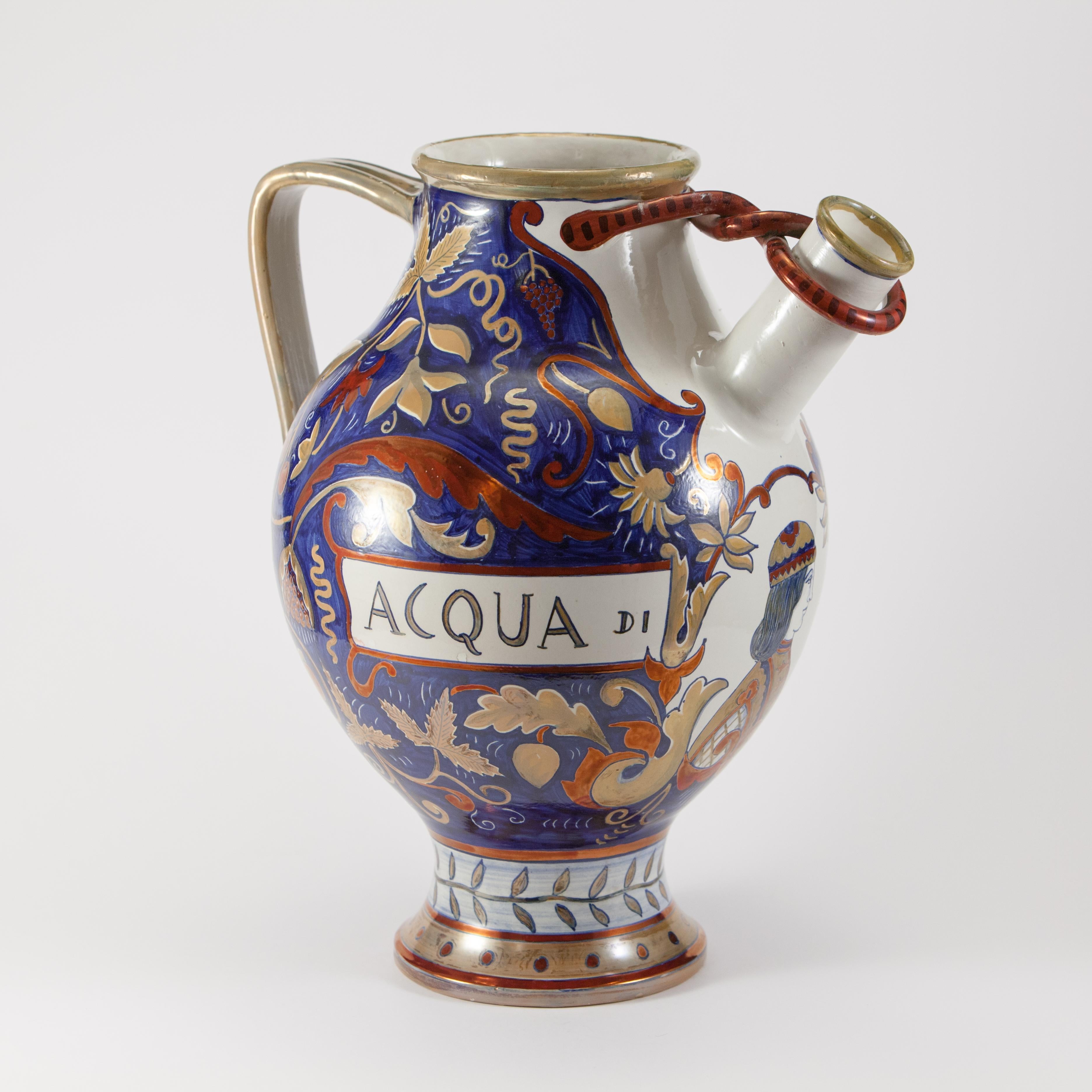 Majolika-Ausgießer mit Henkel, verziert mit Metallglanz im Stil der Renaissance-Majolika in Blau-, Gelb- und Rottönen.
Auf der Vorderseite der Vase befindet sich ein Medaillon mit einer Halbbüste und der Aufschrift 