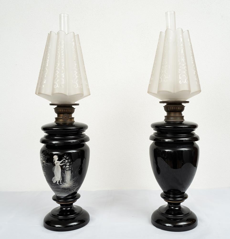 Pair of Neapolitan oil lamps belonging to the second half of the 19th century.

The central stem has white highlights with a scene depicting ladies with flowers.

The top comes with its original machine as well as the glass globe and