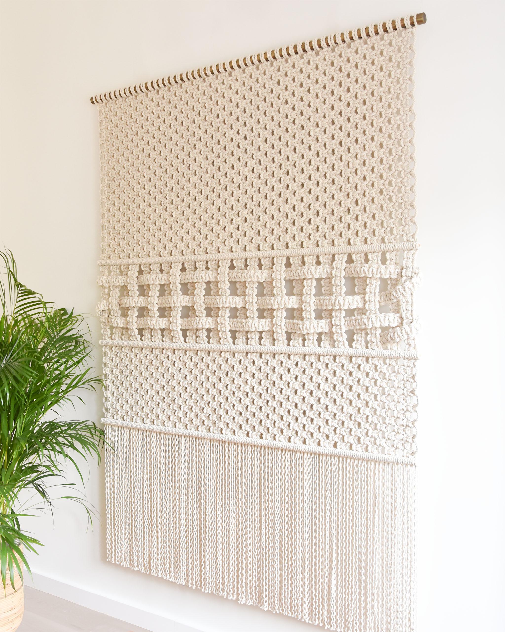 Woven Through Time ist eine Erkundung der Textur, bei der zwei Techniken - Weben und Makramee - kombiniert werden, um einen interessanten, strukturierten Wandbehang zu schaffen.
Mit diesem Wandteppich verfolgt Tamar Samplonius einen skulpturalen