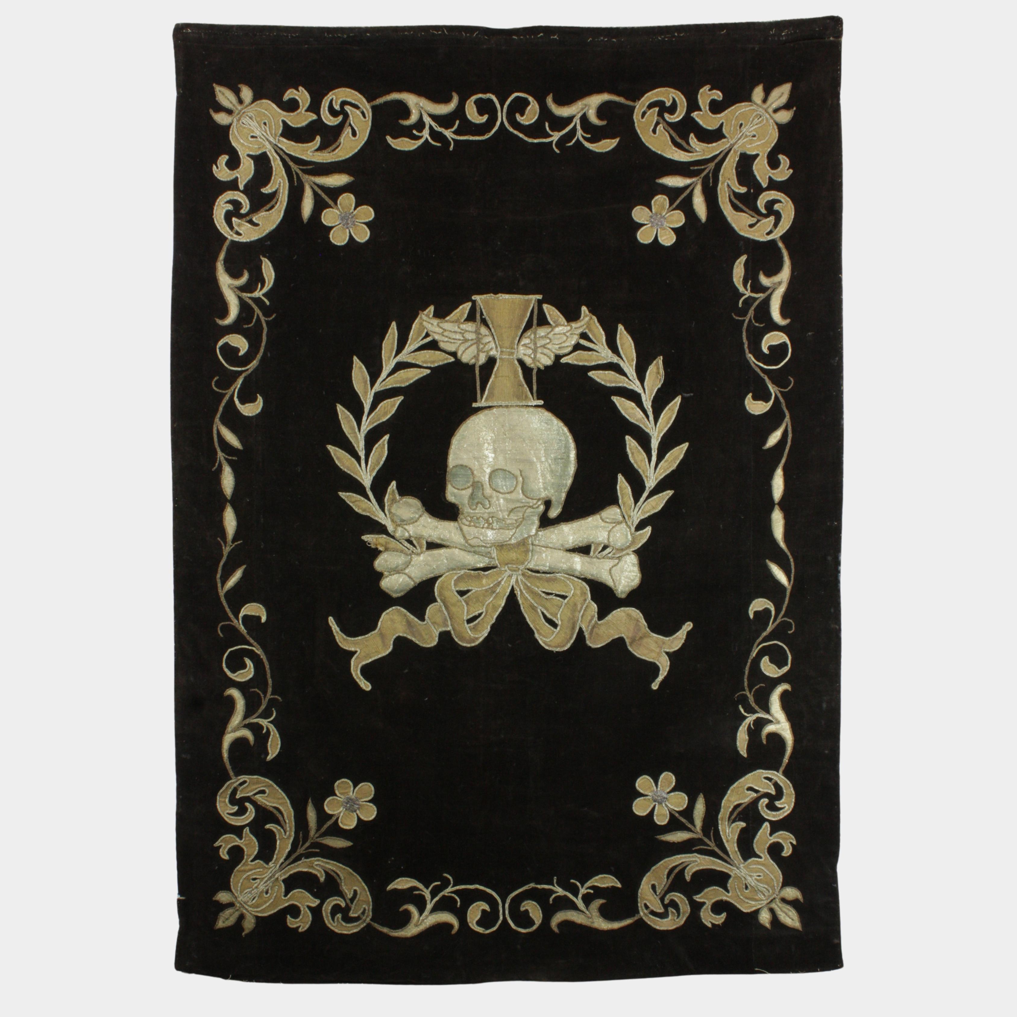 Rare and striking 17th-century funeral vestment, embroidered on both sides with precious silver threads on black velvet, a symbol of mourning and solemnity. One side depicts a skeleton standing on a rock, holding a scythe in his right hand and a