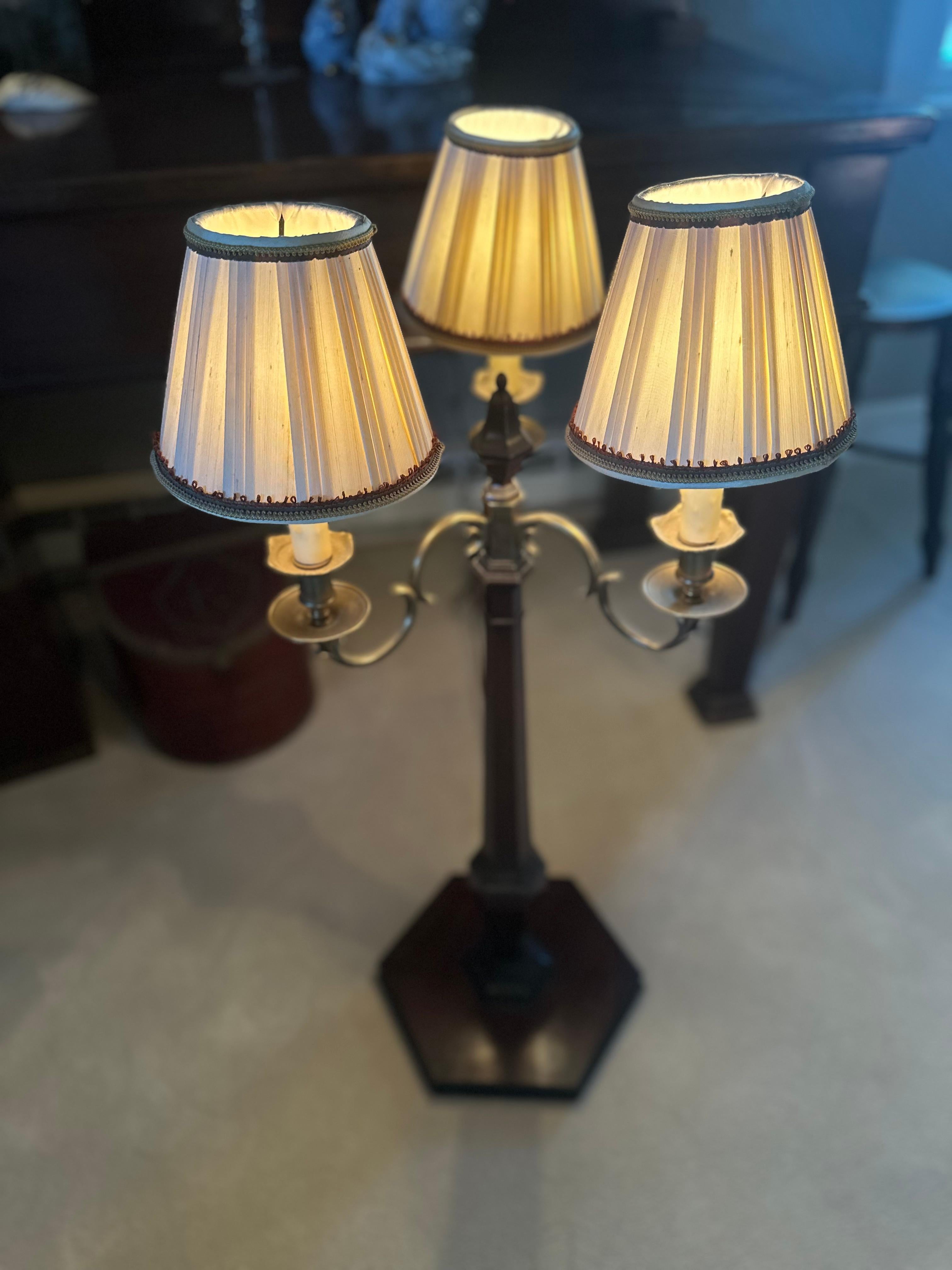La lampada da tavolo a tre braccia in ottone è in ottime condizioni generali.  Circa 1900, combina un'artigianalità classica con un fascino senza tempo. La base in legno aggiunge calore e carattere, evidenziando la qualità dell'artigianato dei primi