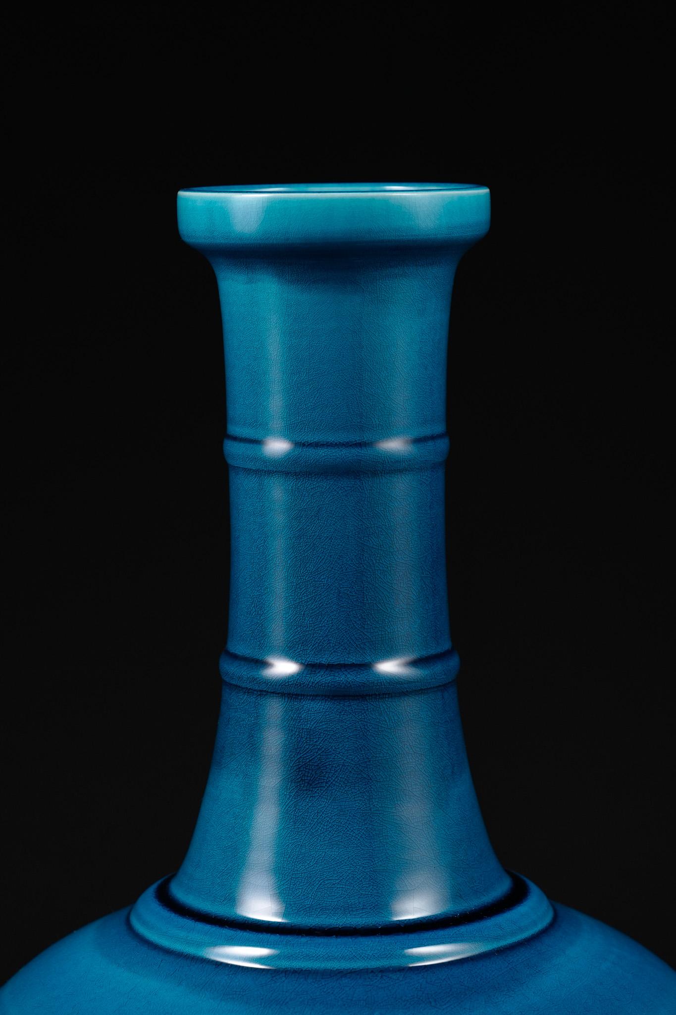 Il Peacock Blue String Vase di Shi Jie Weng unisce la forma classica alla vitalità moderna. Il vaso ha un collo alto e sottile e un corpo pieno e arrotondato, accentuato da molteplici motivi di corde in rilievo tra il collo e le spalle che creano