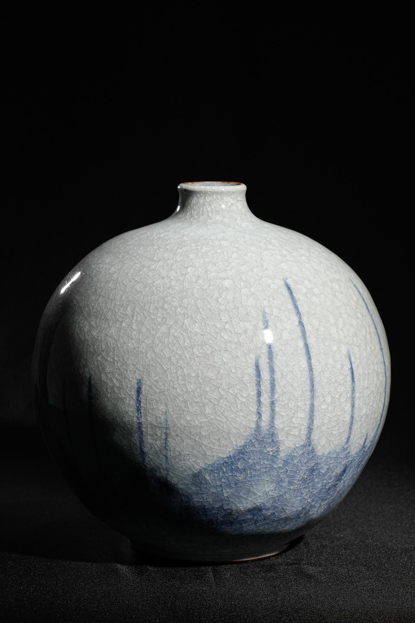 Water Dance, Narrow-Mouthed Round Vase is full and rounded in form, with balanced proportions and a gently constricted mouth that conveys poise and stability. The surface is coated in a luminous blue-and-white glaze, veined with delicate crackle