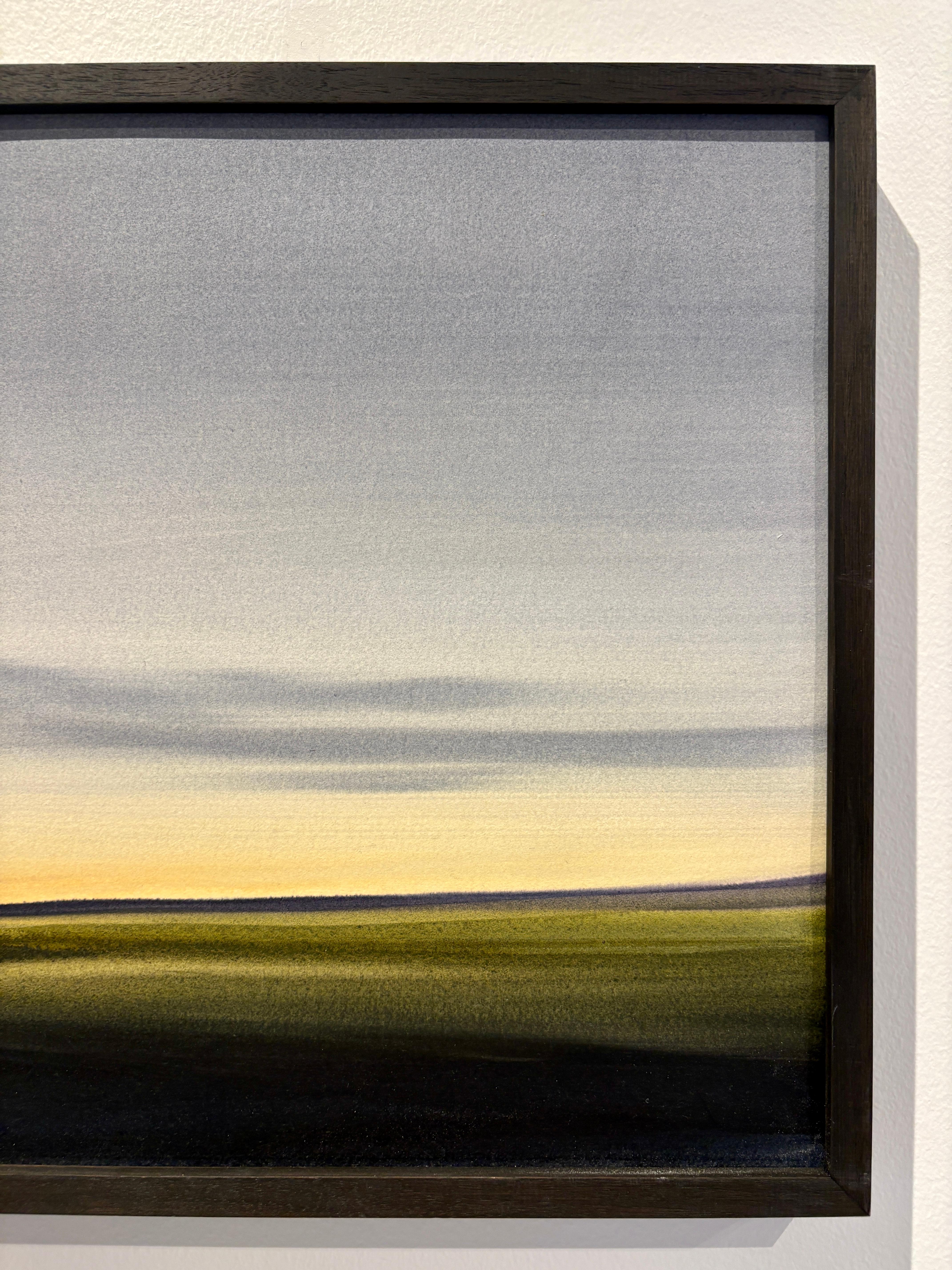 Cette aquarelle de paysage atmosphérique sur papier d'archivage de Dodi Fredericks représente une aube lumineuse et pleine d'espoir au-dessus d'un pâturage assombri mais lumineux. La douceur du lavage donne l'impression d'être en harmonie avec la