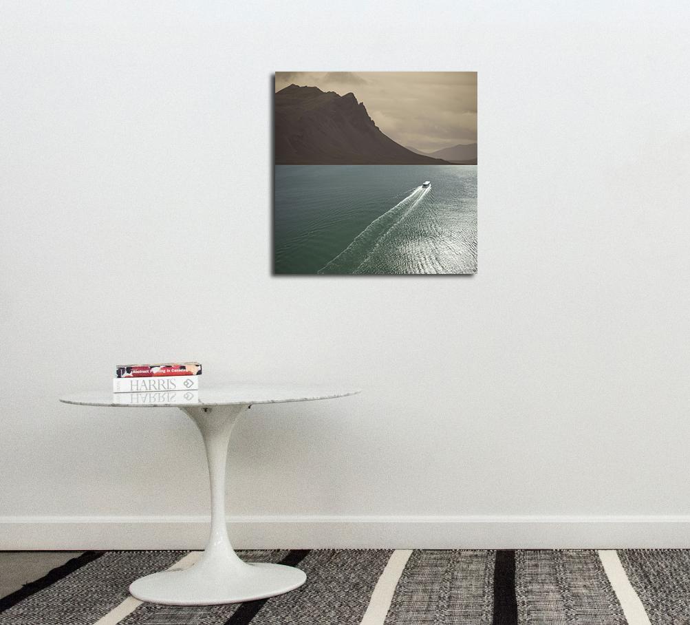 A ferry crosses an expanse of sea towards distant mountains in this photo based artwork by Mark Bartkiw.  The high viewpoint, as though flying over the water, adds to the dream-like quality of the image.  The image is mounted and dibond and sealed