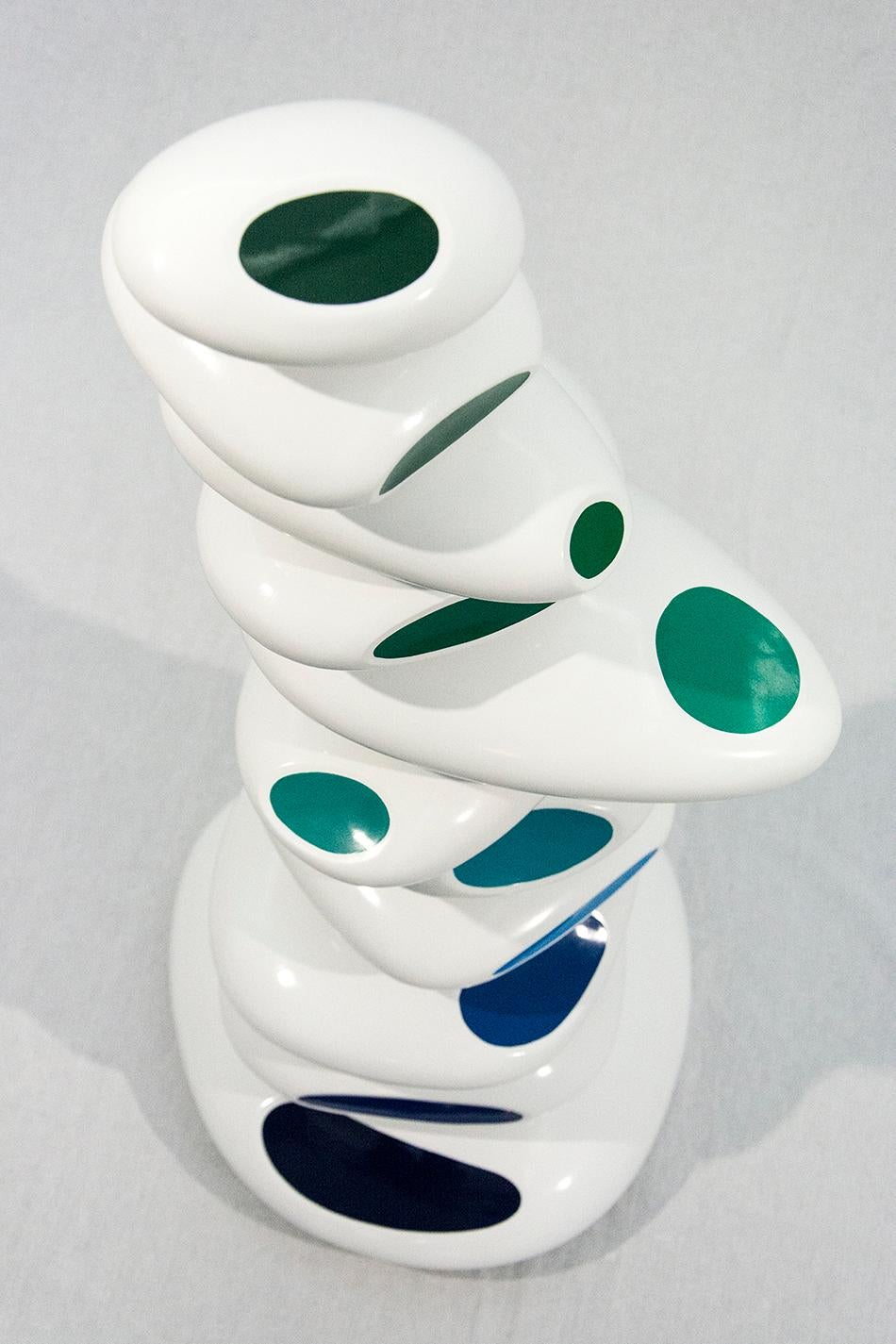 Der israelische Bildhauer Benny Katz schafft mit seinen übereinander gestapelten, glänzenden Ovalen in Weiß mit blauen und grünen Akzenten die spielerische Essenz einer Meereswelle.  Dieses Werk ist die Nummer 2 in einer Auflage von 9 Stück und