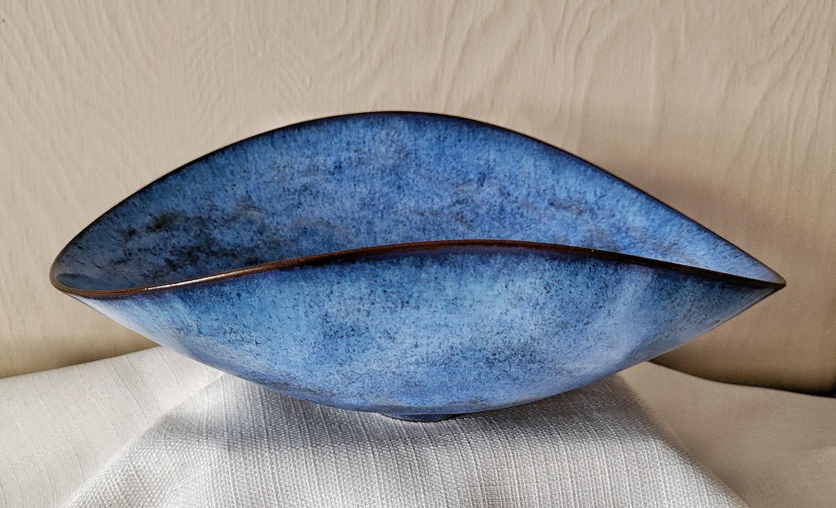 Cette élégante coupe ovale d'Otto et Gertrud Natzler présente l'un des émaux les plus séduisants du couple au milieu du siècle : un bleu œuf de merle à la texture douce et aux variations tonales subtiles. Mesurant 9,25 × 7,25 × 4 pouces, ce