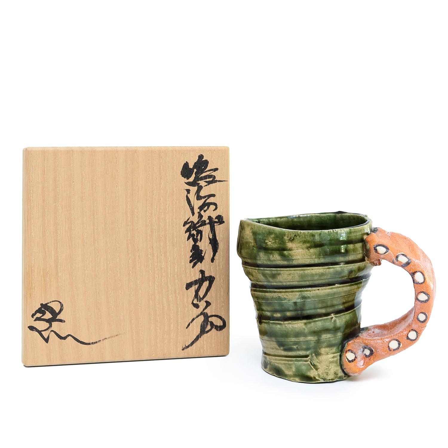 Suzuki Goro - Oribe Mug
stoneware, underglaze and glaze
3.75 x 5 x 3.5”
date unknown 
signed
comes with a signed wooden box

BIO- 
Revered Japanese ceramic master Goro Suzuki has had a long, successful career, beginning as a production potter and