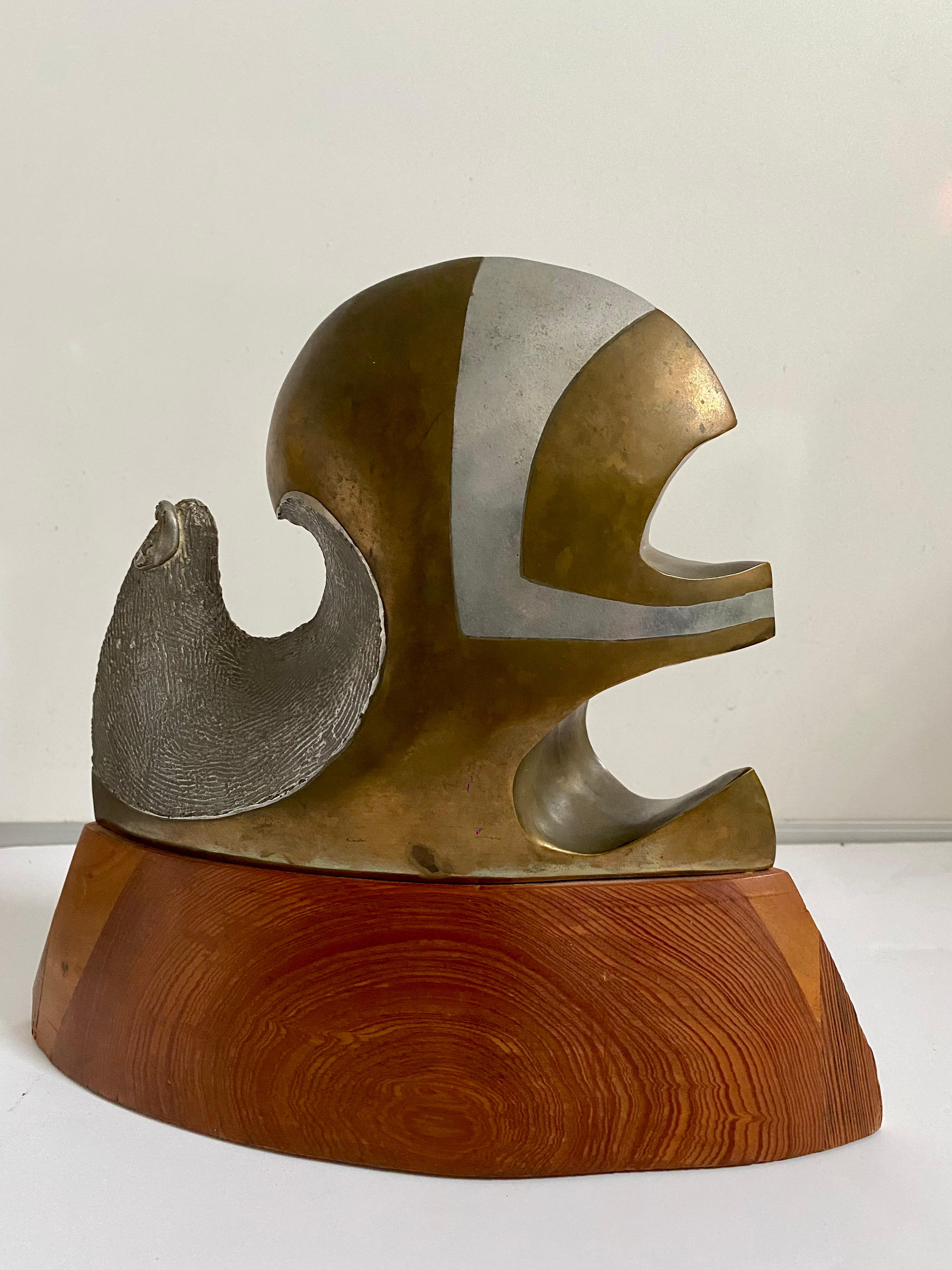 Chester L. Williams
Label on bottom, signed. Title: Promethium
Medium: Bronze, Aluminum and wood. 
Approx. dimensions: 12 X 11 X 4 inches. 

Chester Lee Williams (1944-1919) was born in 1944, in Durham, North Carolina. Chester cultivated a creative