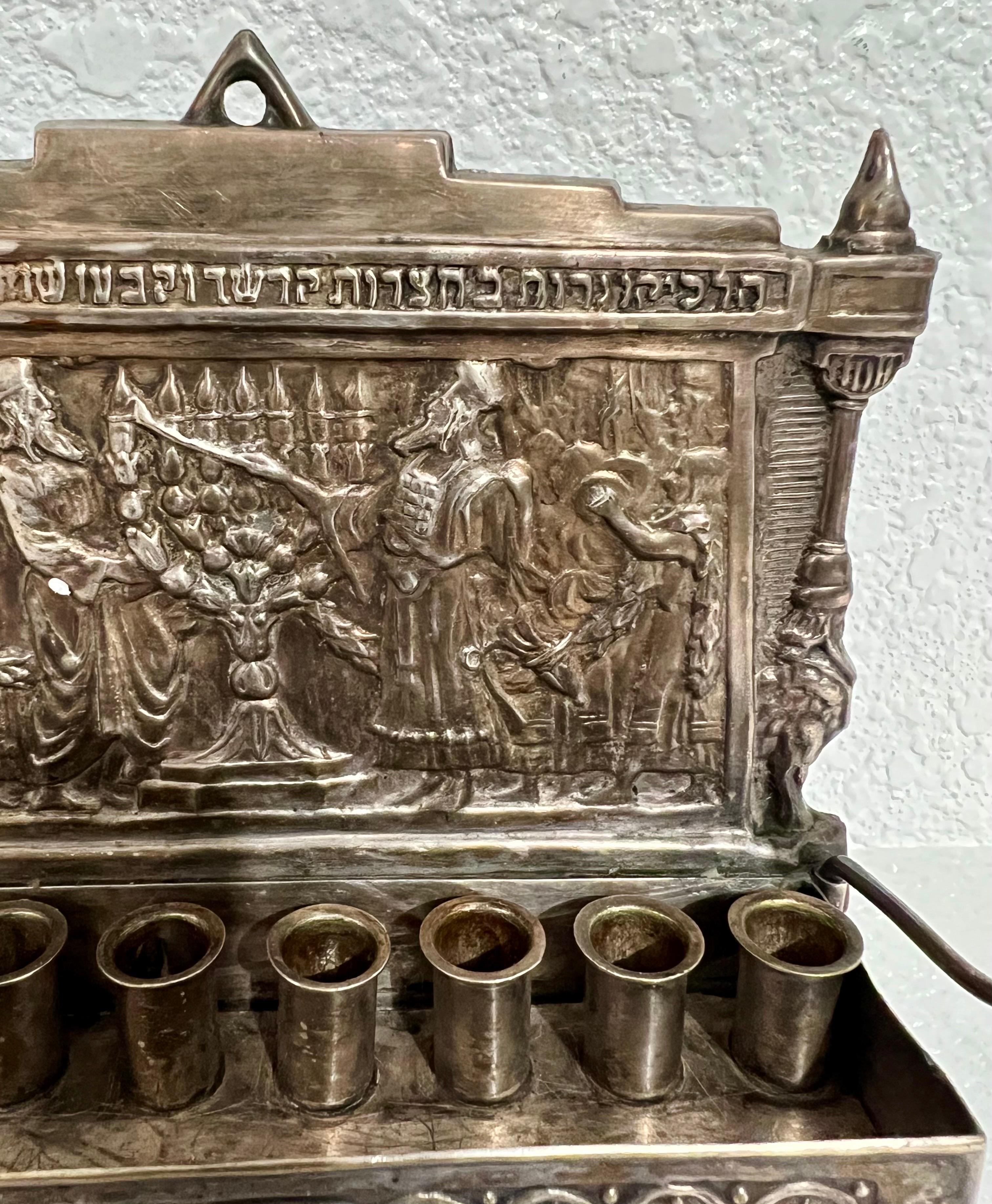 For standing on feet or as a wall hanging with a hole at the top for mounting on the wall. Original Bezalel School brass bronze menorah with the original silverplate intact. Including the servant light Shammash (which is more rare) and having all 8