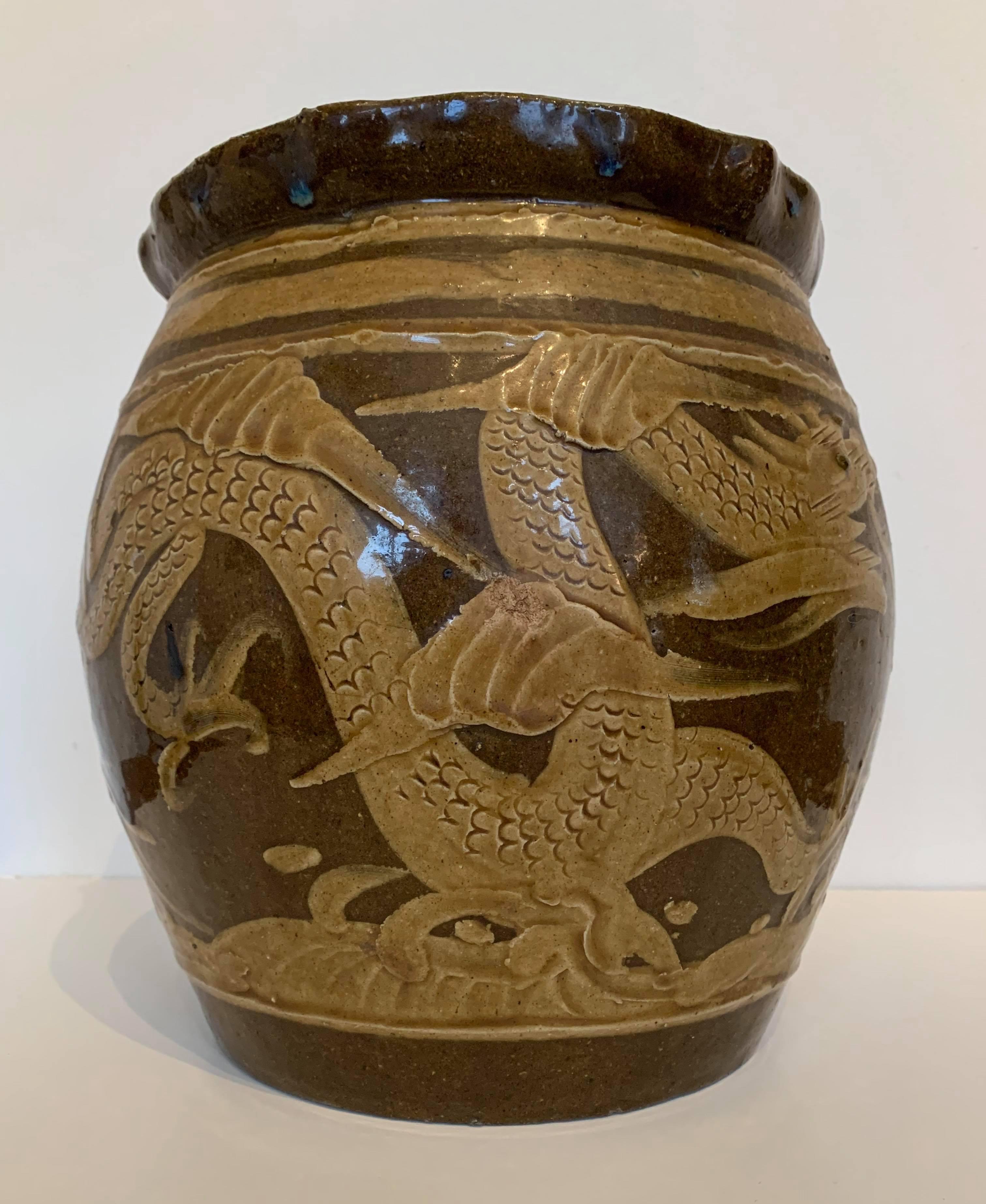 Cette jardinière chinoise du XIXe siècle présente des dragons dans différentes nuances de tons de terre glacés et une glaçure turquoise à l'intérieur. Il présente un bon équilibre et une silhouette agréable ; il a également une belle patine. Il y a