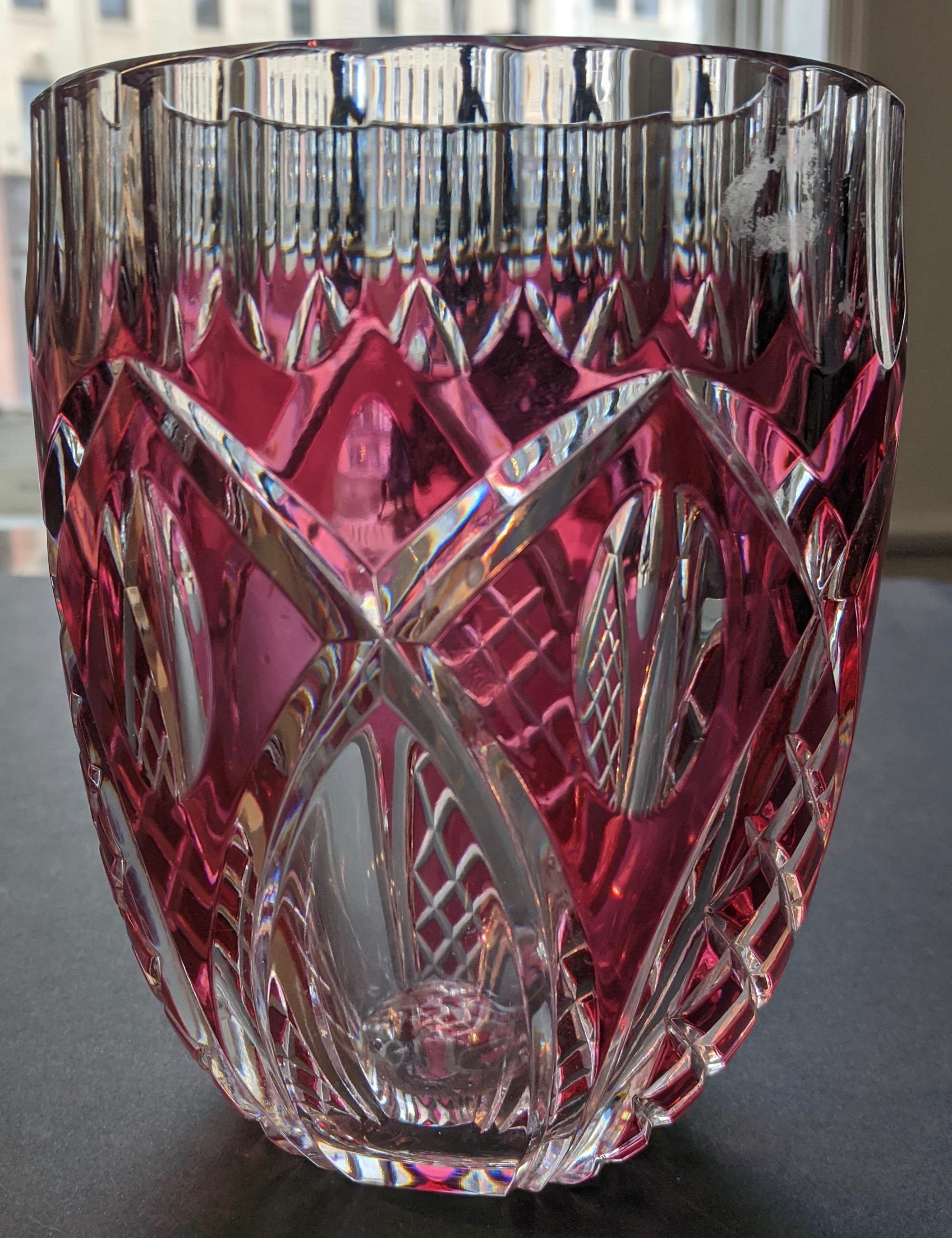 Ce vase en cristal Val St. Lambert provient de Belgique et a été fabriqué à la fin des années 1950, début des années 1960. Il s'agit d'un verre épais d'une couleur framboise intense. La pièce est fabriquée à la main et en cristal facetté, présentant