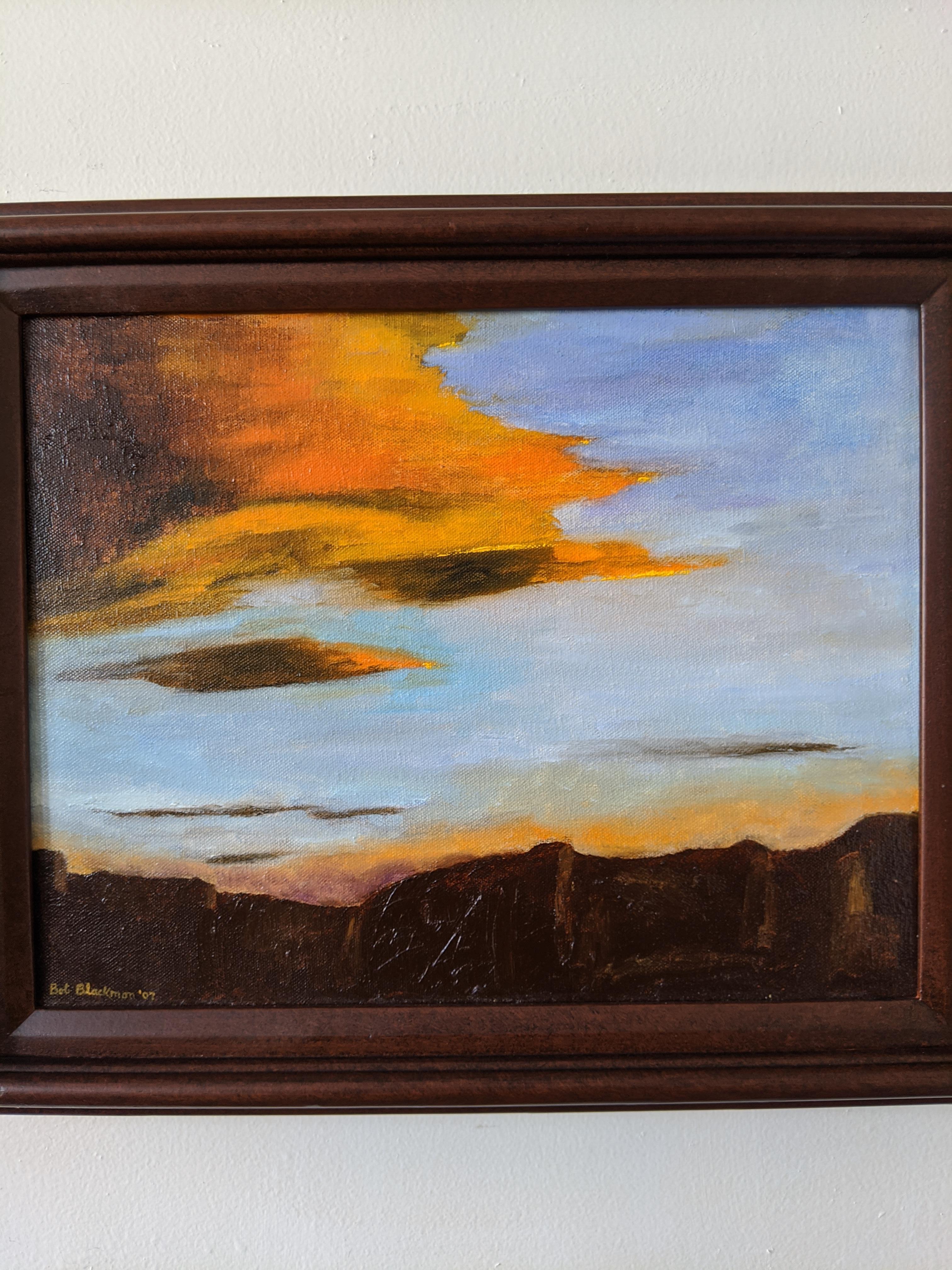 This oil on canvas piece features a vibrant sunset with a complementary color scheme of orange and blue. The burnt umber rock and patches in the sky ground the composition and balance out the expanse of the horizon. The clouds reflect the warmth of