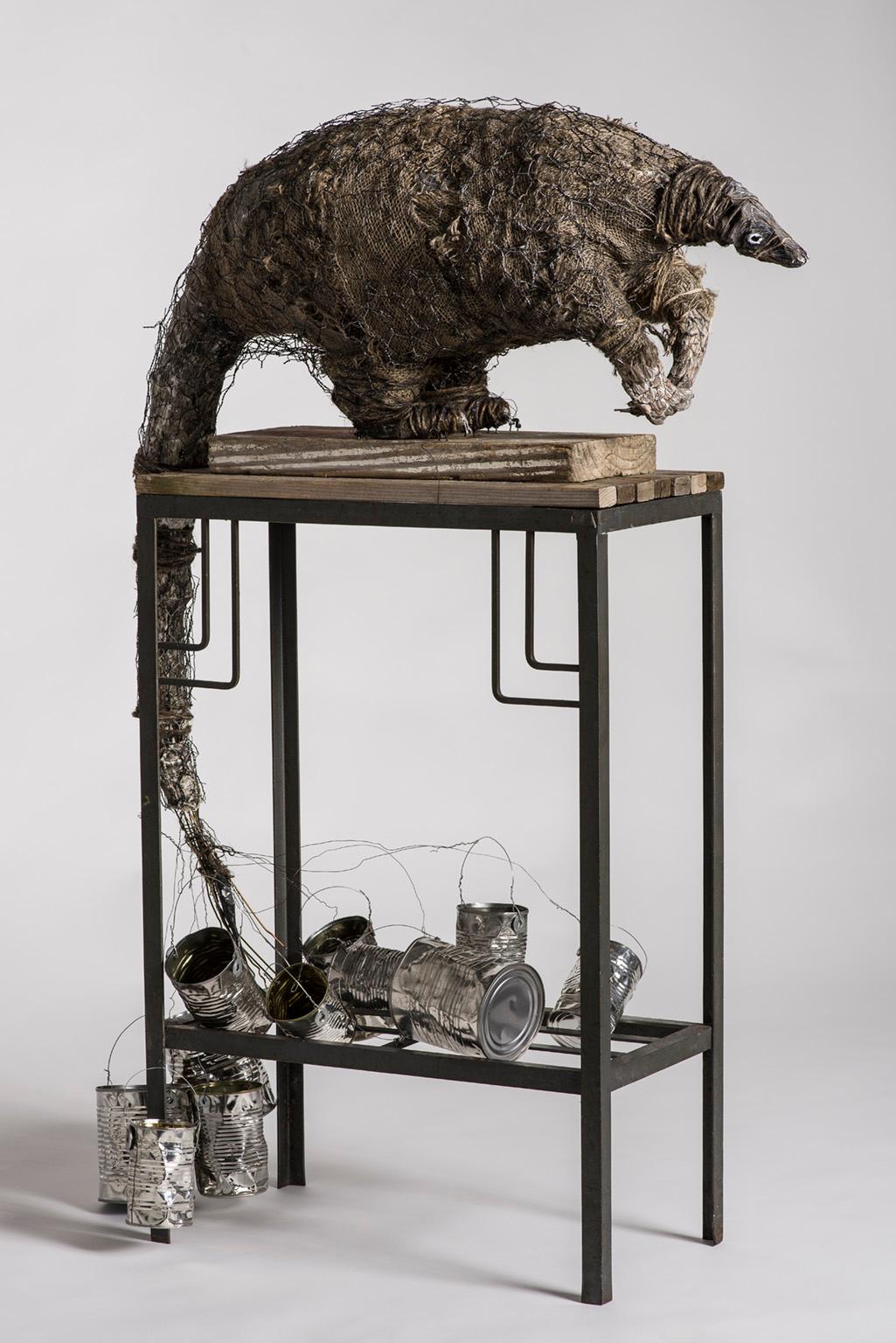 Anteater sculpture on high platform with tin cans: 'A Grim Fairy Tale'