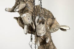 Kaninchen in Ketten zusammengefasst, erdfarbene Skulptur: „Der Mondglasurschäler“