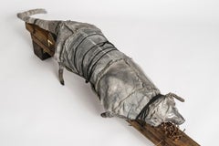 Cat lying on wood block, earth tone sculpture: 'Beyond The Door'