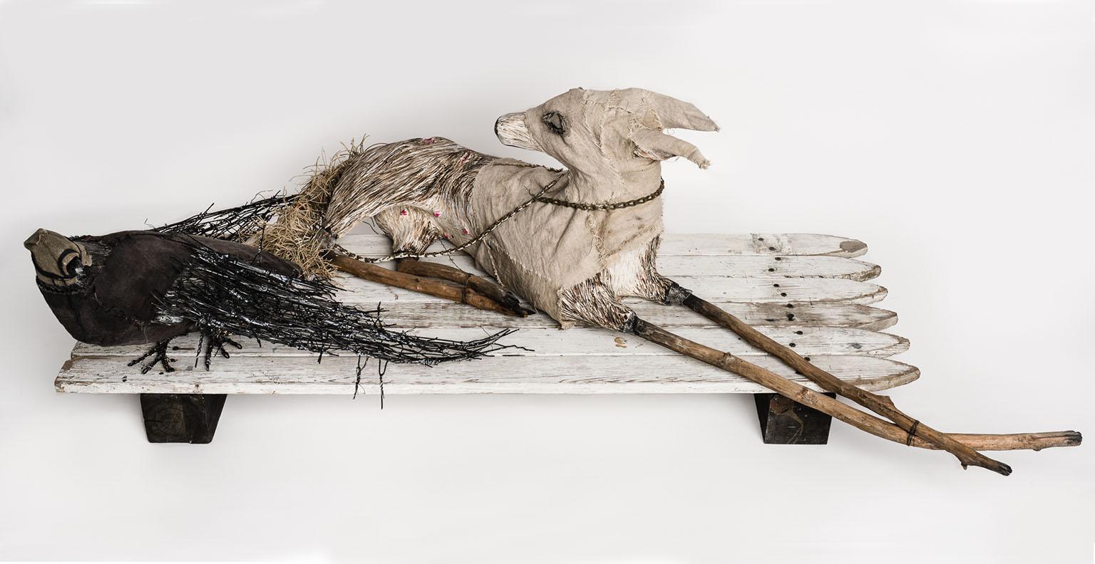 Scultura di un cane e di un corvo sulla recinzione: 'Filosofia del mondo'