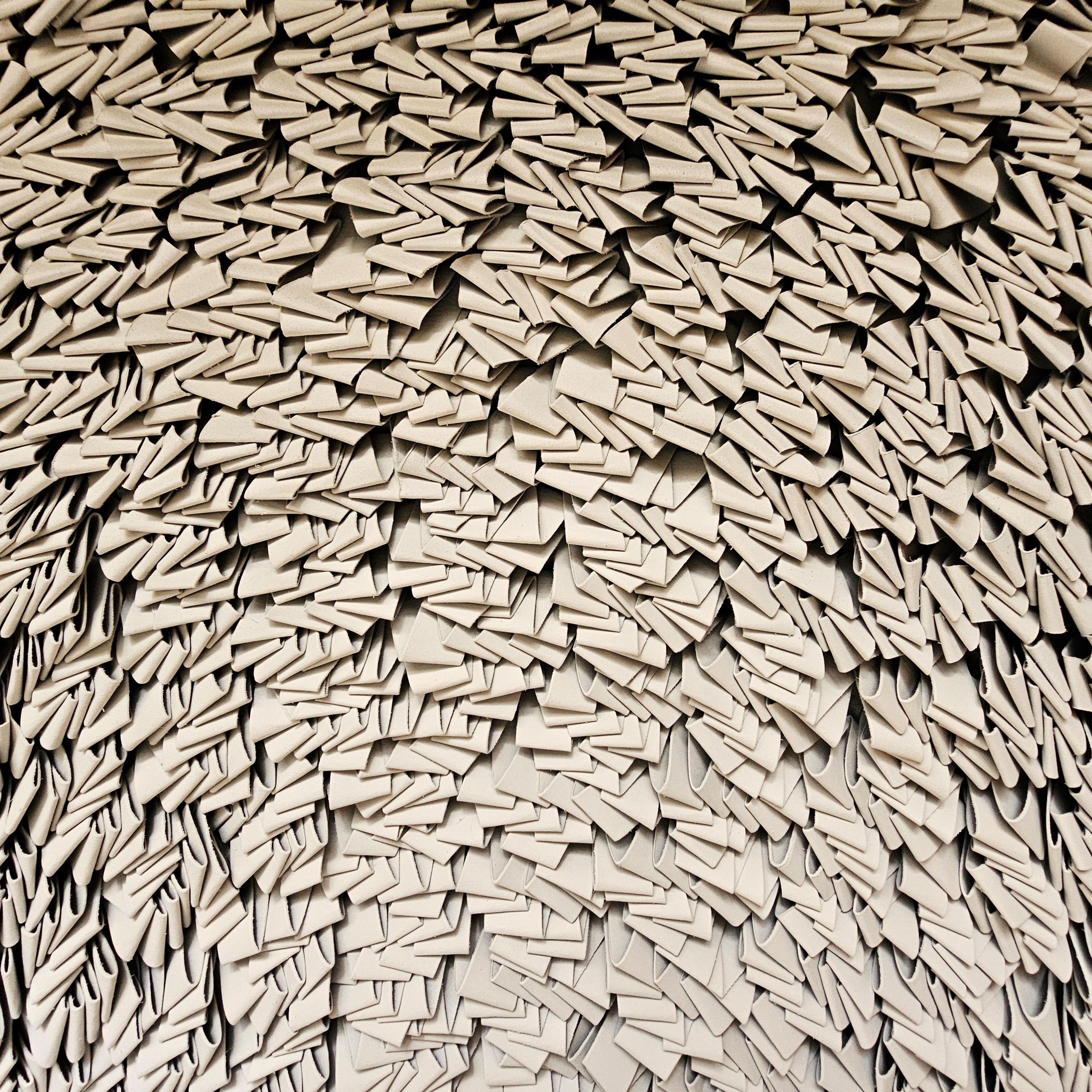 Le processus commence par la disposition minutieuse de bandes de papier, qui se chevauchent pour créer de la profondeur et de la dimension. Cette technique permet non seulement de mettre en valeur la matérialité du papier, mais aussi d'explorer la