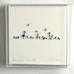 Blue hand cut figures pinned on paper framed in acrylic box. 3D. In stock 