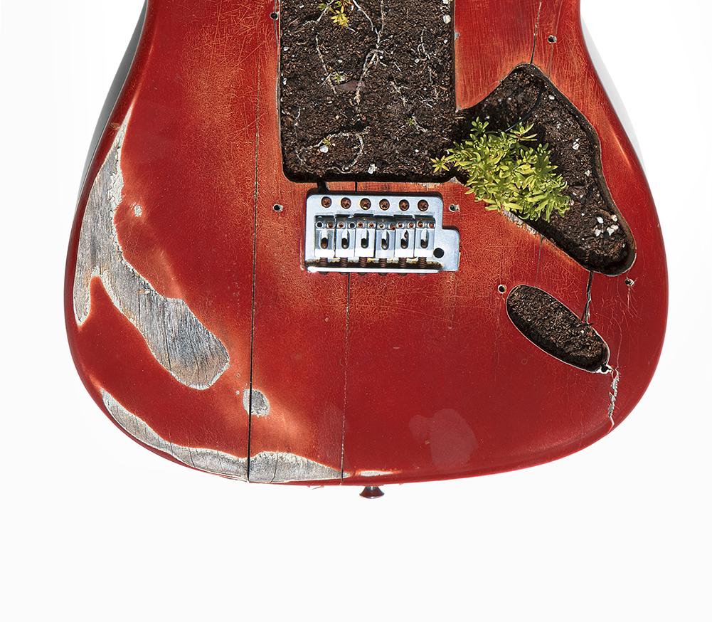 quelque chose m'a fait commencer. Photographie couleur d'une sculpture de corps de guitare assemblée - Rouge Color Photograph par Kevin Krag