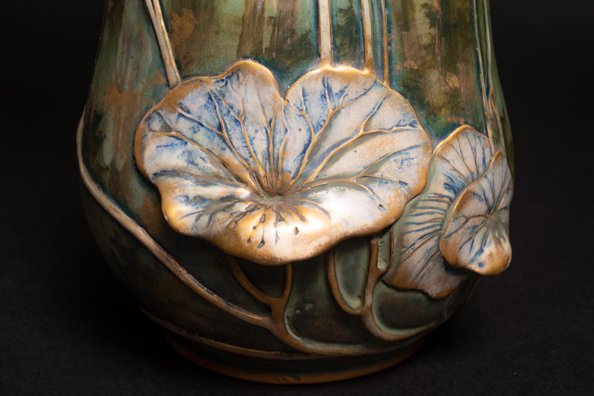 
NOCTURNAL RISING BAT VASE by AMPHORA, Model #668, c. 1900, in porcelain with applied detailing of bats, fruiting stalks and lilies interpreted as opium poppies, the vase has an iridescent pink underglaze that is enhanced with gold paint and a