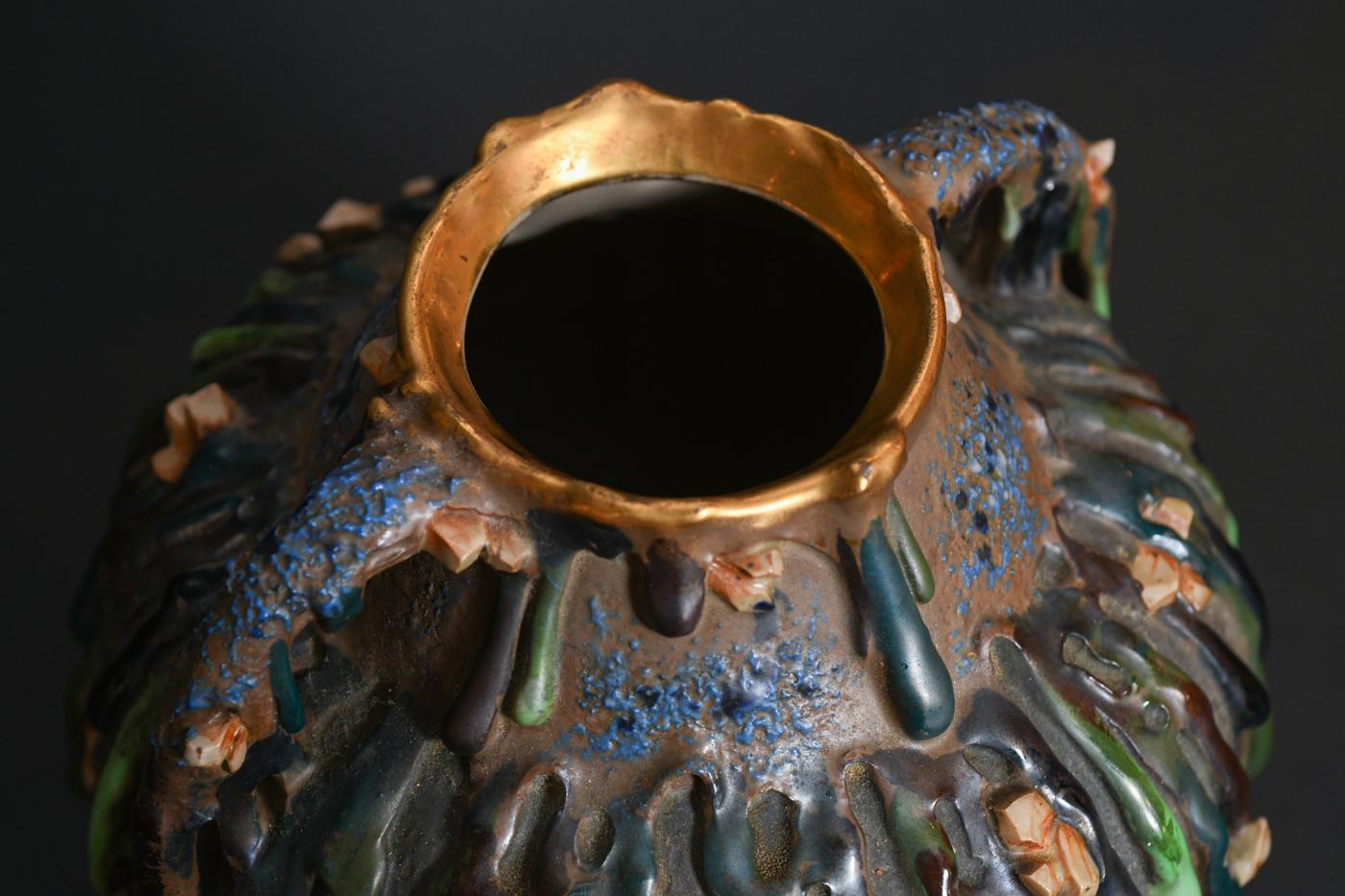 The virtuosic blending of color and texture shows how inventive decoration can triumph over nondescript form. Brightly colored drips of slurry clay cascade like melted wax down the two-handled jug-like body, whose shoulder and lower body exhibit