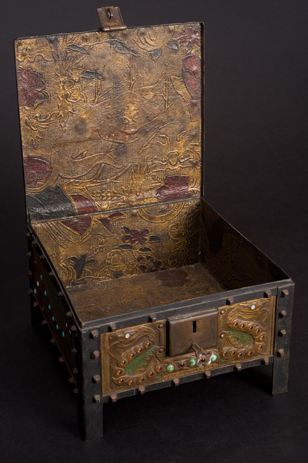 VIPER BOX, by Alfred Daguet (French, 1875-1942), dated 1907; an iron footed box whose prominent square nail heads lining the sides and its locking mechanism make up a Medieval design aesthetic, fitted with brass panels decorated in repoussé, painted