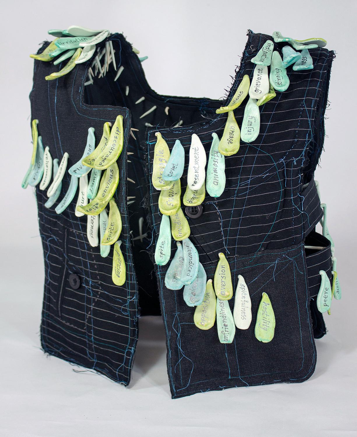 "Envy", mixed media, vest, ceramic, black, green, teal, white, sculpture