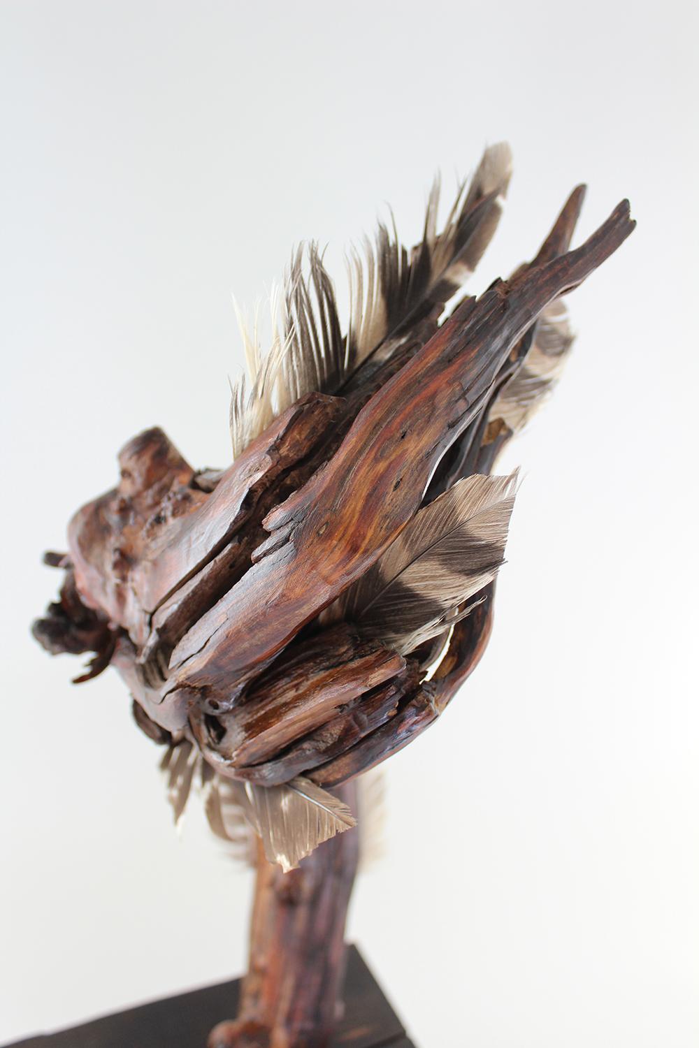 Miller Opie’s “Ascending Flourish” is a gestural 21 x 8.5 x 6.25 inch Mountain Laurel wood sculpture with found feather details embedded into the wooden grain. Opie used the natural twist of the wood to create movement which is enhanced by the