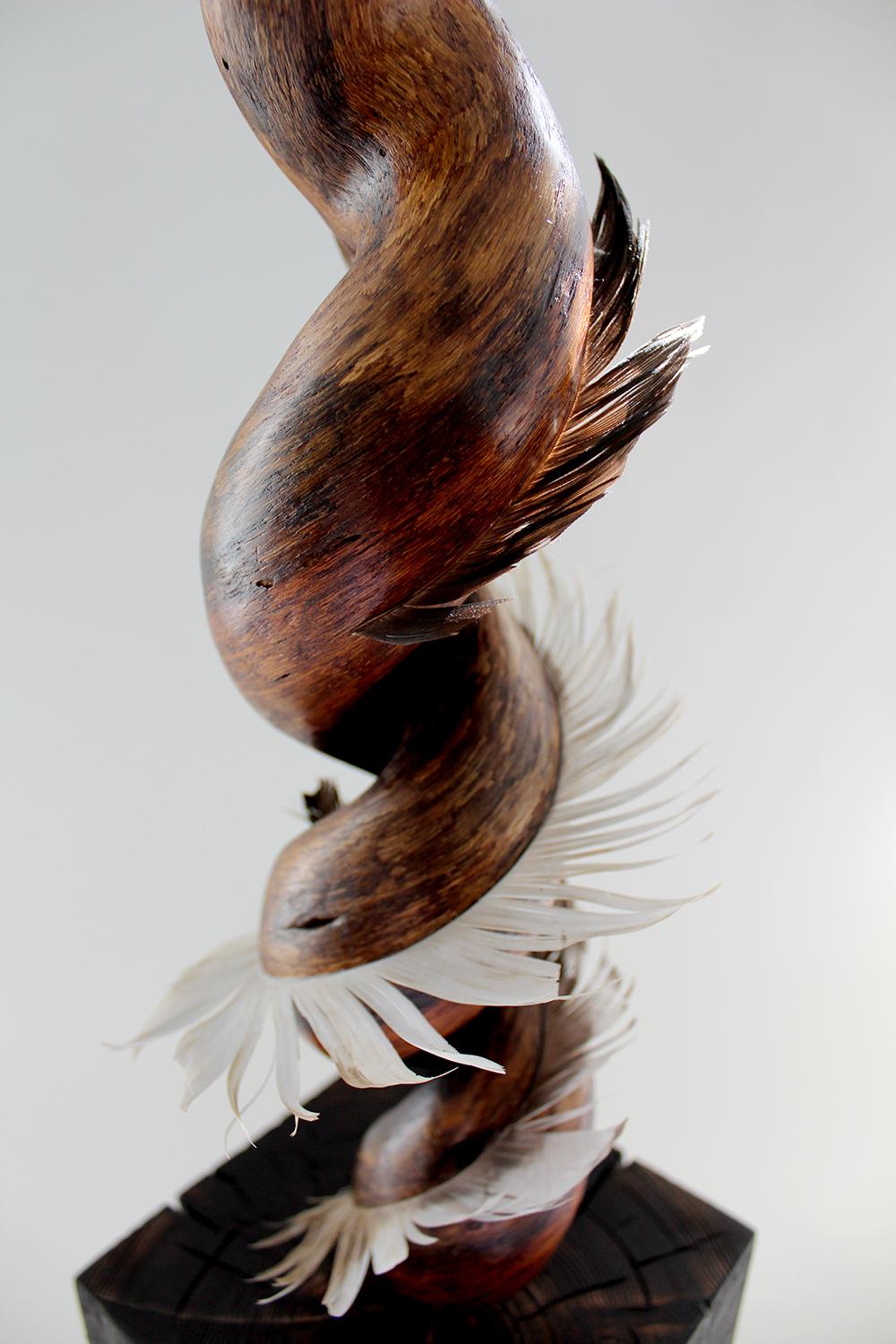 Miller Opie’s “Swishing Larkspur” is a gestural 27 x 6 x 6 inch White Oak wood sculpture with found feather details embedded into the wooden grain. It is the fifth piece in her 8 piece 