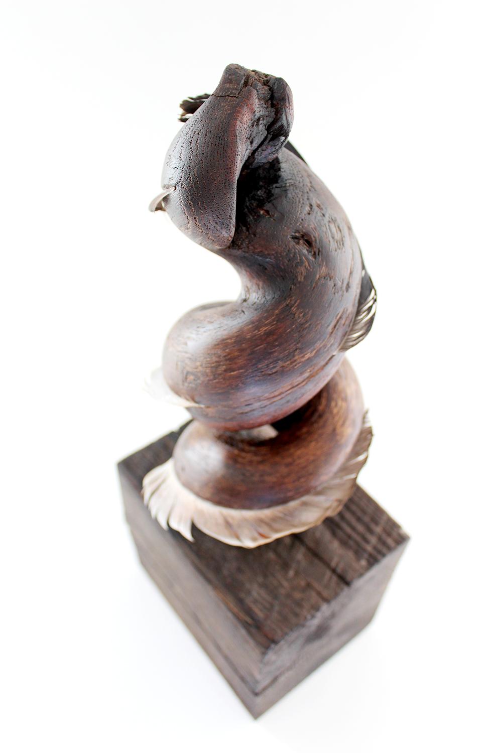 Miller Opie’s “Whispering Dervish” is a gestural 13.5 x 5 x 4 inch White Oak wood sculpture with found feather details embedded into the wooden grain. It is the third piece in her 8 piece 