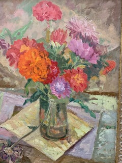 Still life of Red and Orange Flowers in a glass vase on a table