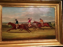 English horse racing scene with three horses and jockeys in mid gallop