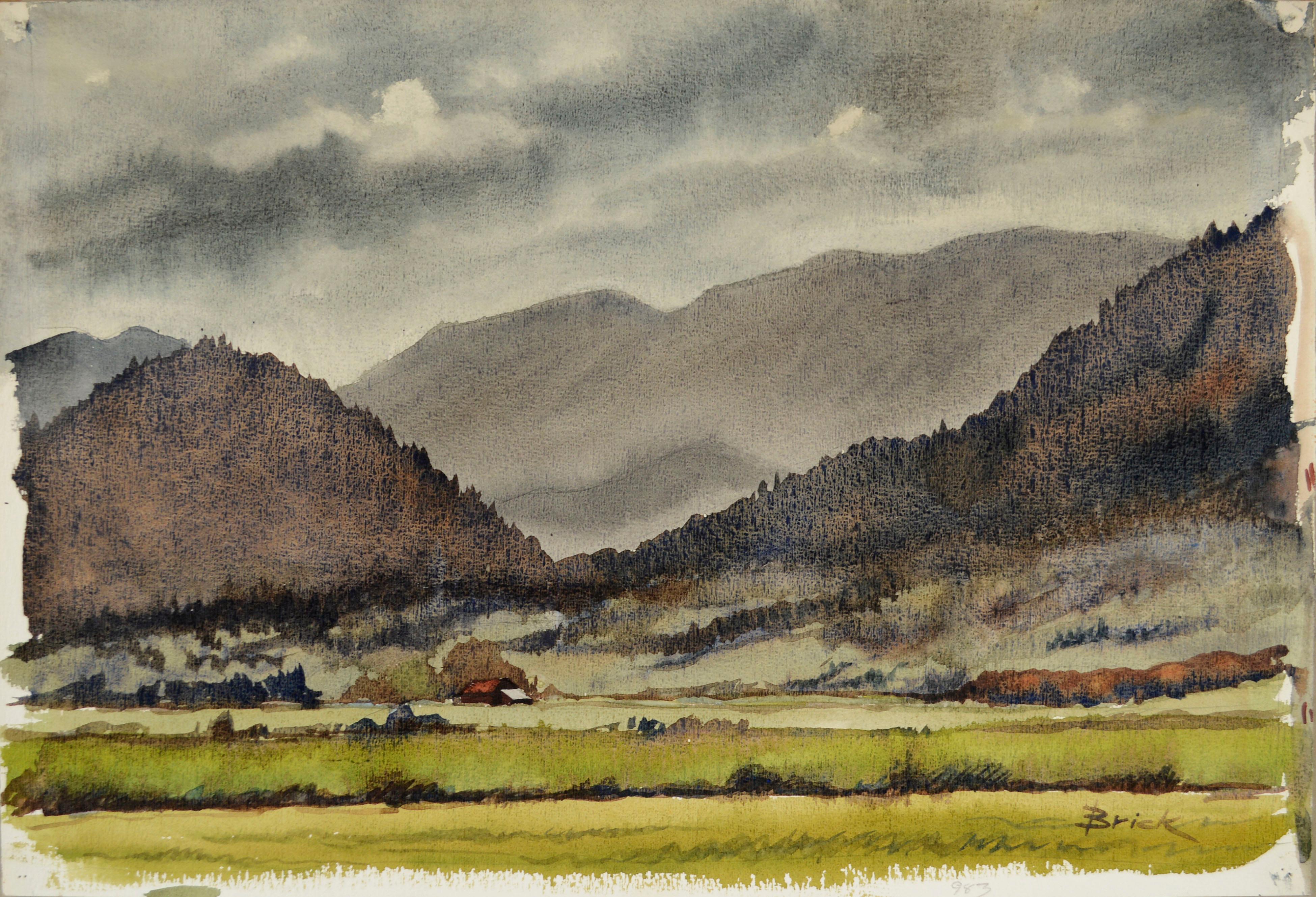 Verdant landscape watercolor of the beautiful Willamette Valley under a cloudy sky by Oregon artist Walter Jim Brick (American, 20th Century). A tiny red farmhouse is nestled beside expansive and dramatic mountains and sky, giving this landscape a