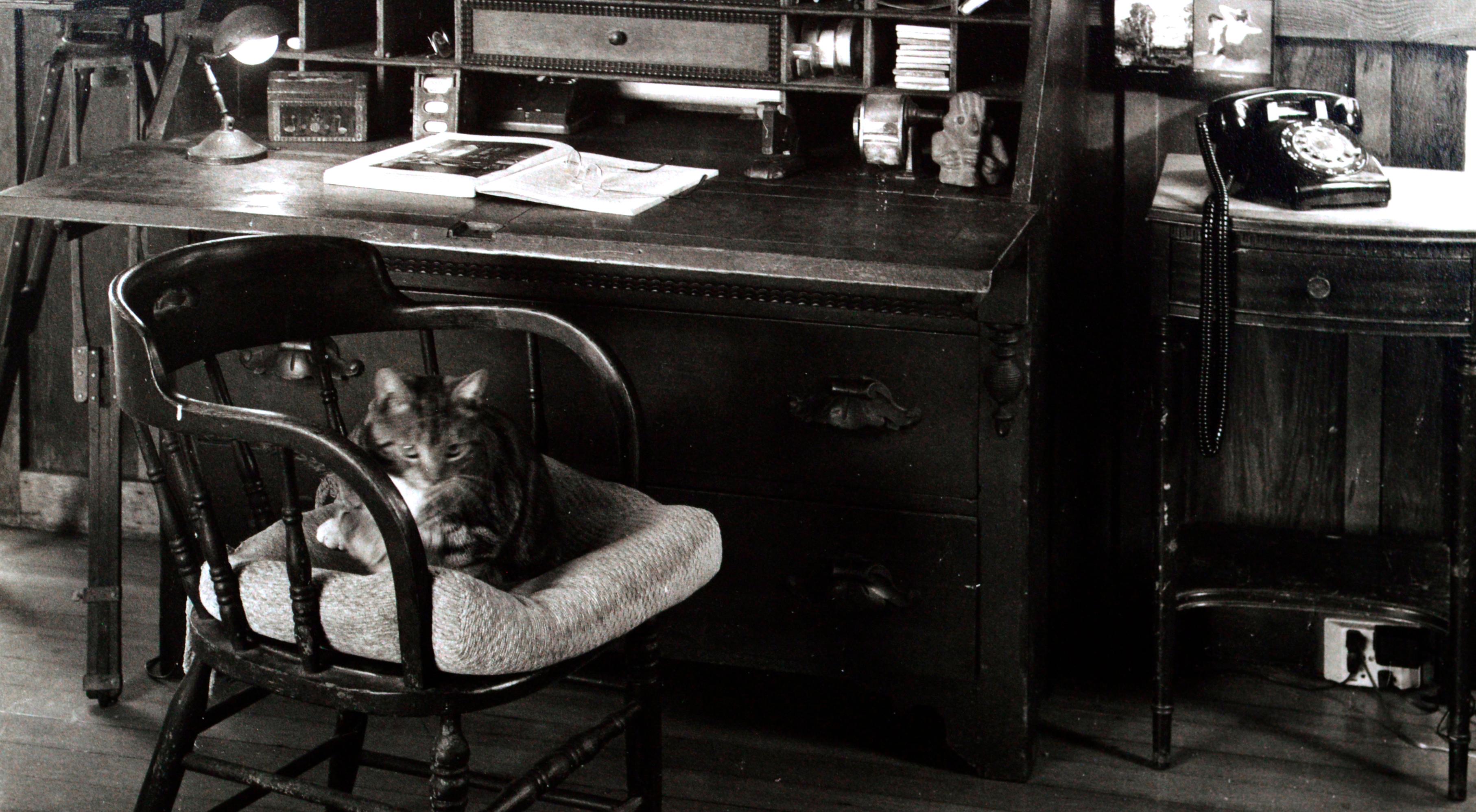 Black and white photograph of Edward Weston's desk, by Kim Weston (American, b. 1953). This photograph was taken in the former home of Edward Weston, Kim Weston's grandfather, and antique camera equipment can be seen in the photograph. Signed 