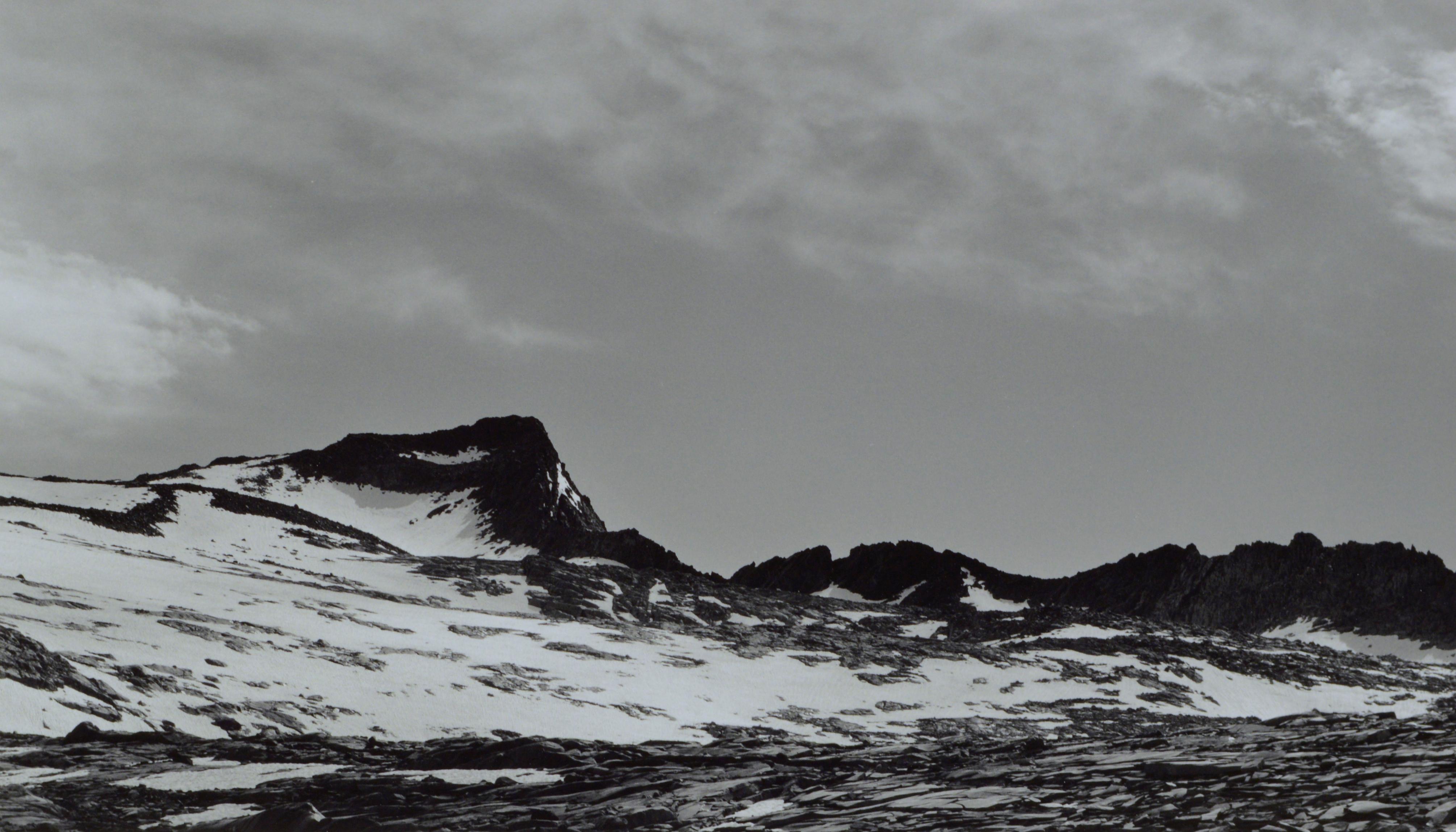 Élégante photo en noir et blanc signée à la main, mettant en valeur le contraste saisissant entre la chaîne de montagnes du Yosemite, le mont Lyell, et les magnifiques nuages qui le surplombent, par Charles Cramer (Américain, né en 1950). Signé