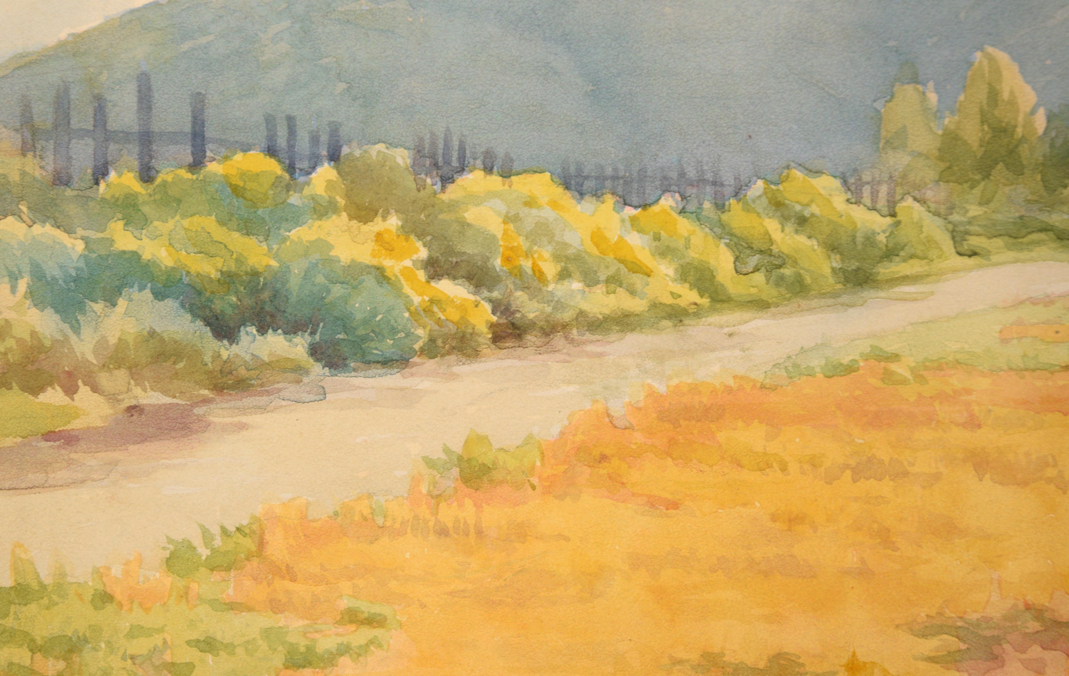 Vibrant watercolor by an unknown artist, in the style of Elmer Wachtel (American, 1864 - 1929). This mid-century landscape watercolor features a golden yellow meadow beside a country road that follows a picket fence through a California valley,