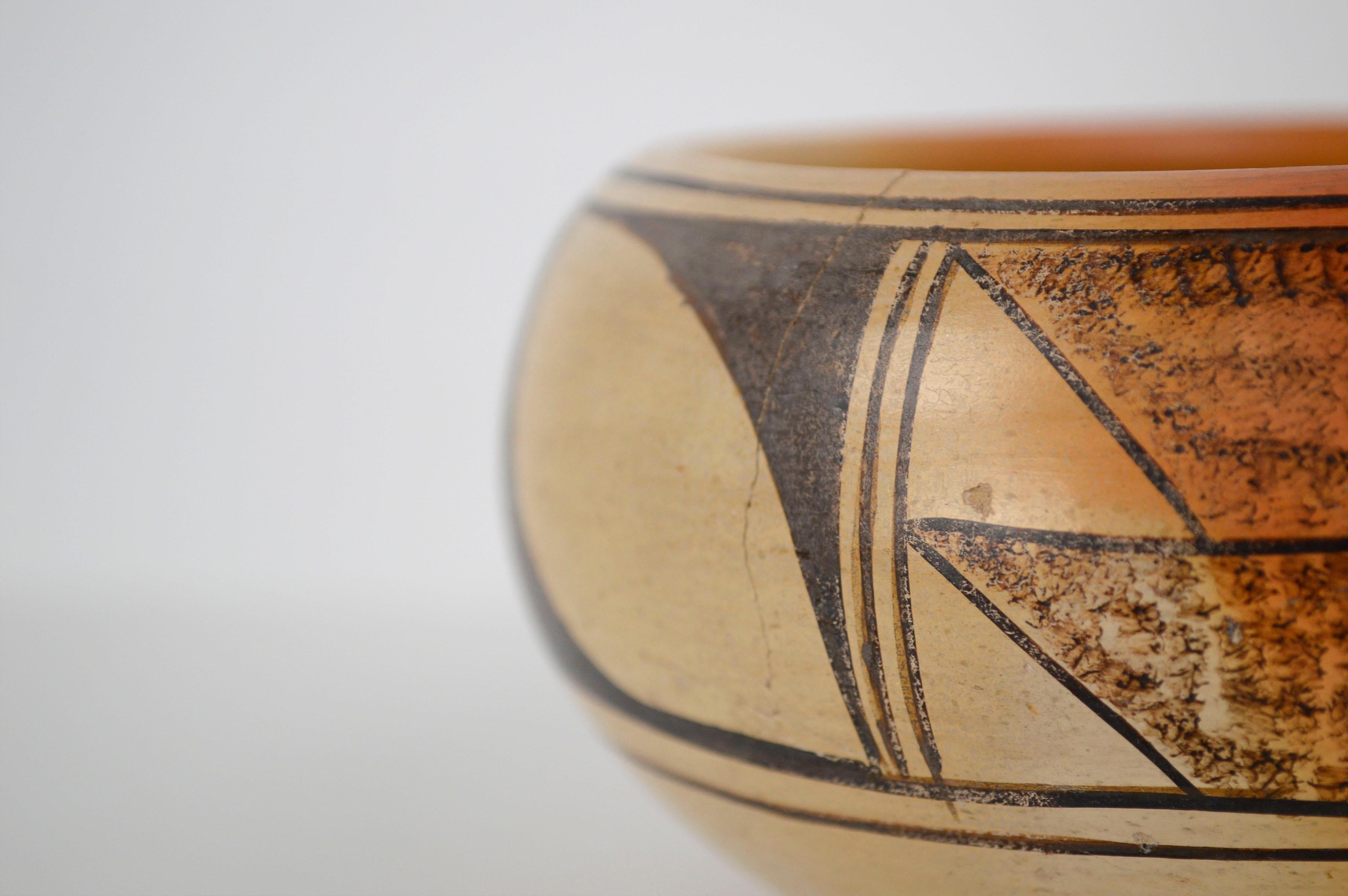 Traditional Hopi/Tewa handmade Native American pottery bowl, with black motifs on yellow polychrome, by Laura Chapella Tomosie (Hopi, 1907-1977), c. 1930's. Signed 