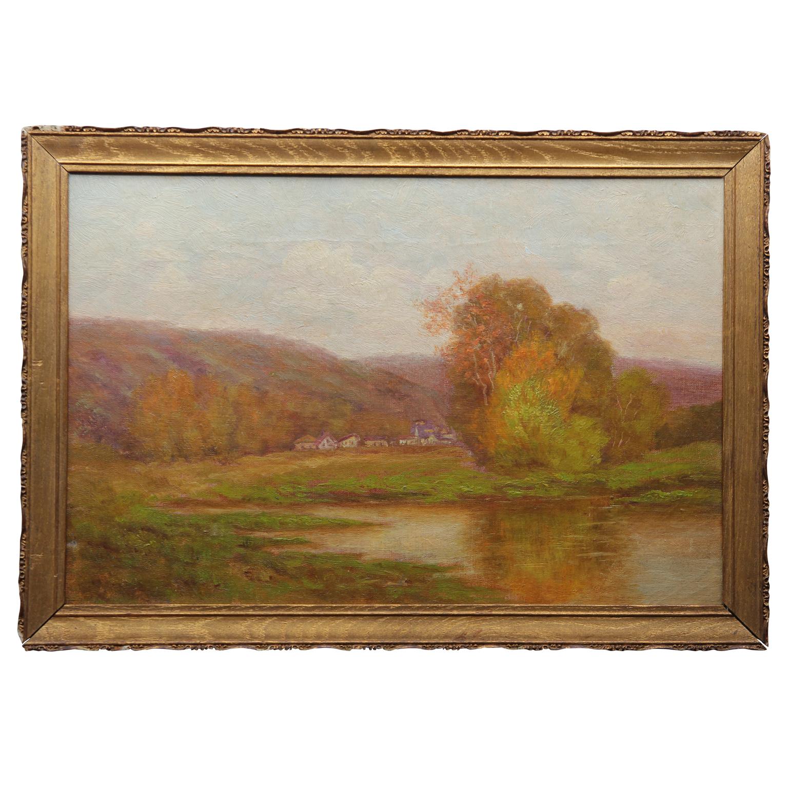 A traditional pastoral landscape with a small town at the foot of hills in the background. There is a lake in the foreground. The work is framed in a thin gold wooden frame. On the canvas stretcher the initials A. V. Tack is written in