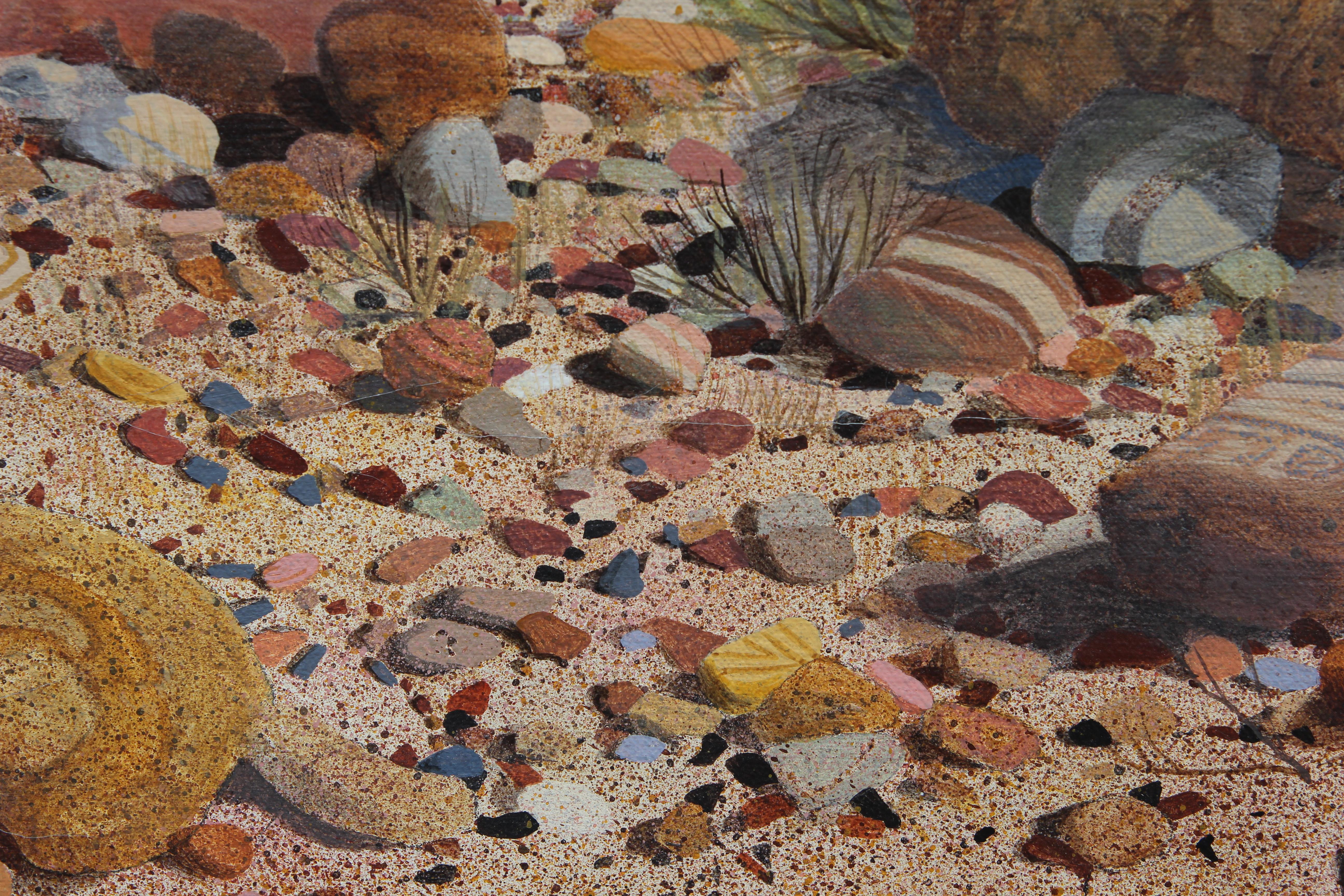 Hyper-realistic landscape painting of a desert landscape with mountains in the background. In the foreground is a well-painted collection of colorful rocks. The work is signed by Dennis Culver who is known for painting realistic landscapes. The