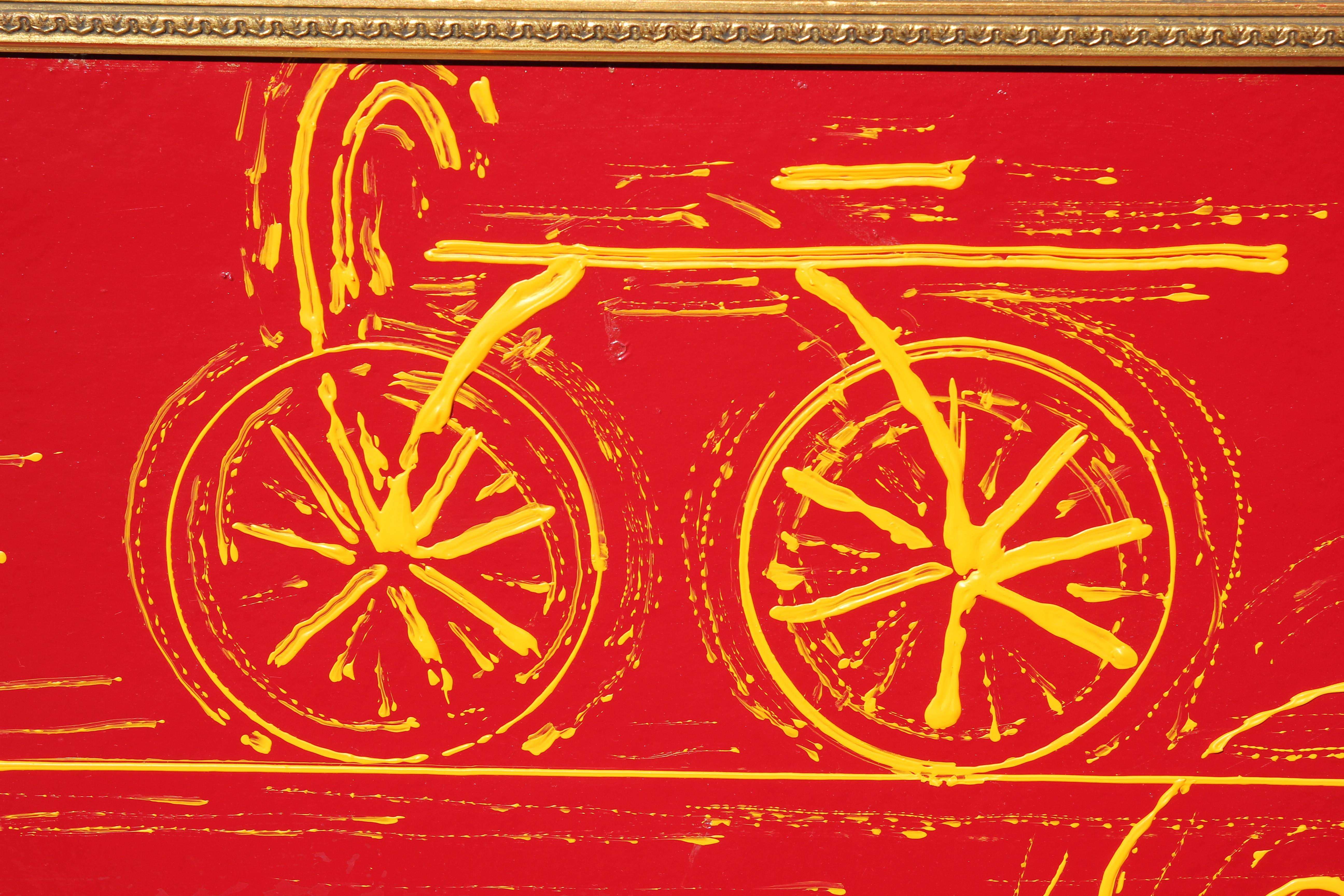 Peinture abstraite minimale aux tons rouge et jaune avec des bicyclettes. L'œuvre est signée par l'artiste dans le coin inférieur. Le tableau en toile est encadré dans un cadre doré. 
Dimensions sans cadre : H 31.5 in x L 47.5 in