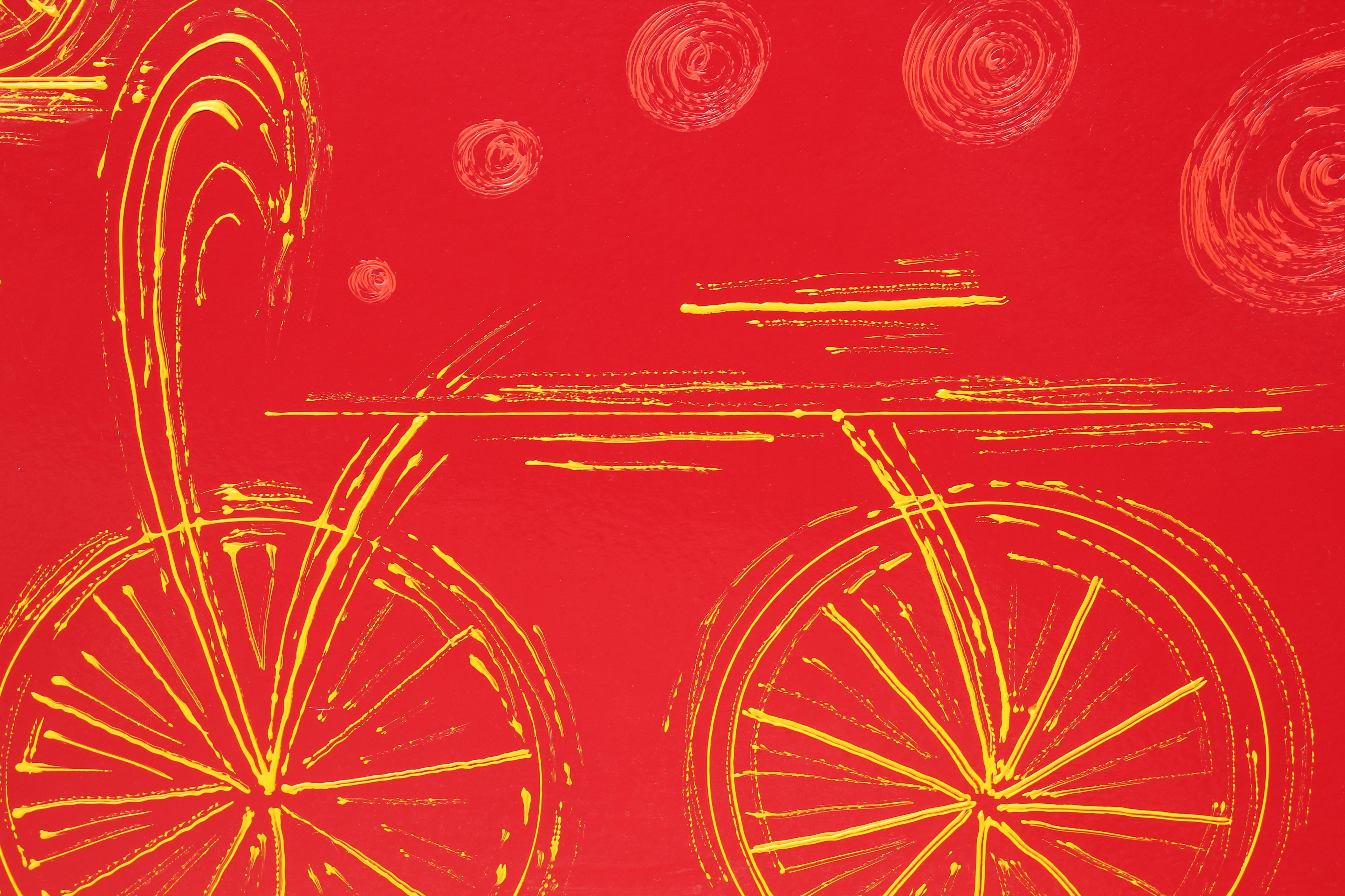 Red and yellow tonal minimal abstract painting with bicycles. The work is signed by the artist in the bottom corner. The canvas board is framed in a gold frame. 
Dimensions without Frame: H 31.5 in x W 47.5 in